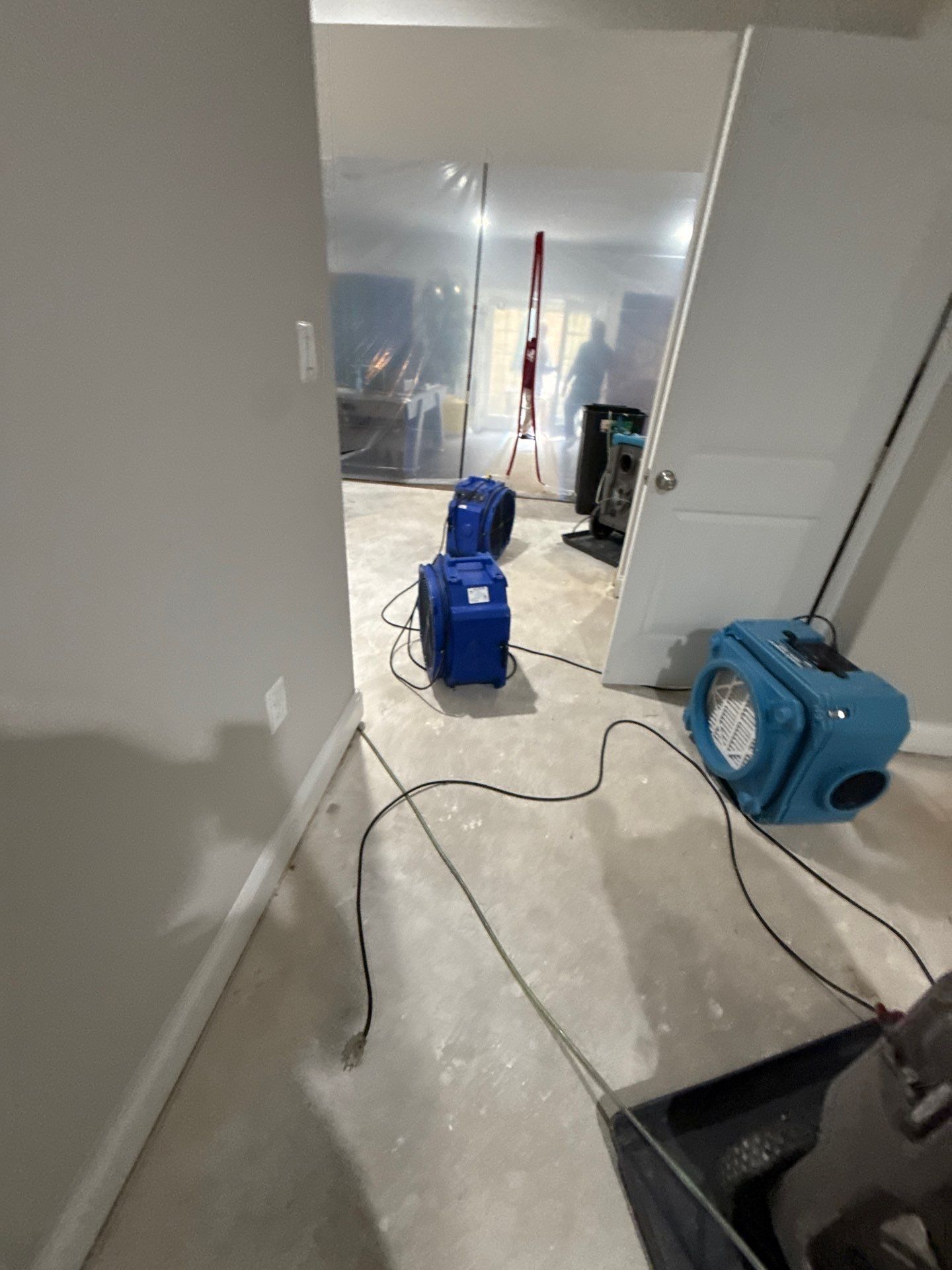 Standing water extraction underway in Herndon water damage restoration, industrial extractor removing pooled water from flooring.