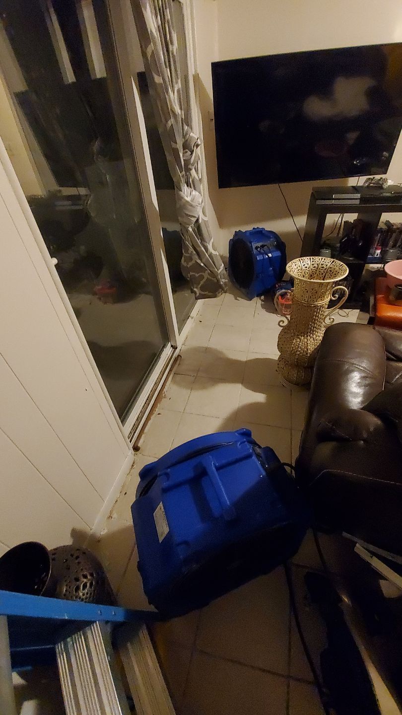 Standing water extraction underway in Woodbridge water damage restoration, wet flooring visible.