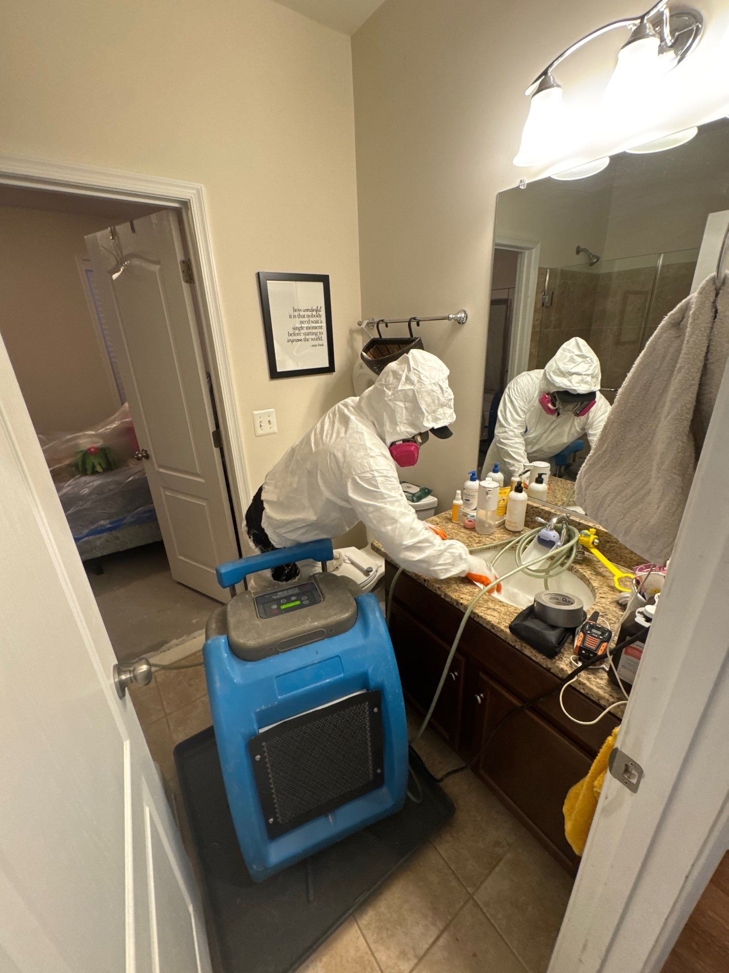 Dehumidifier and air movers positioned in affected room to accelerate structural drying after water intrusion.