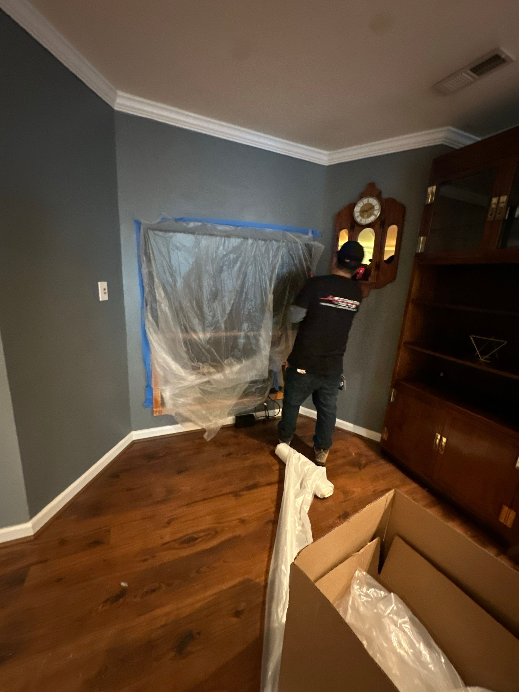 Flooring and carpet removal underway to expose subfloor and framing for thorough drying.