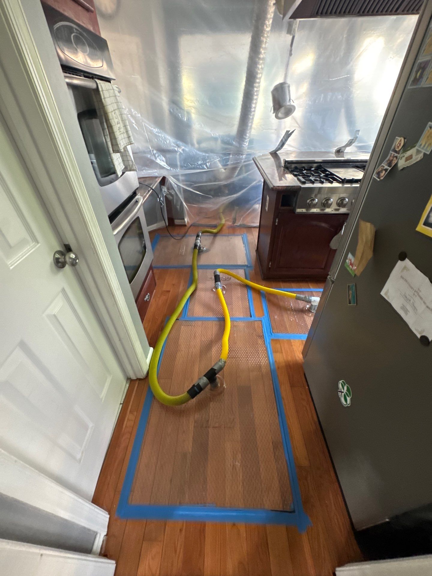 Continued drying and dehumidification within containment barrier as ceiling restoration progresses.