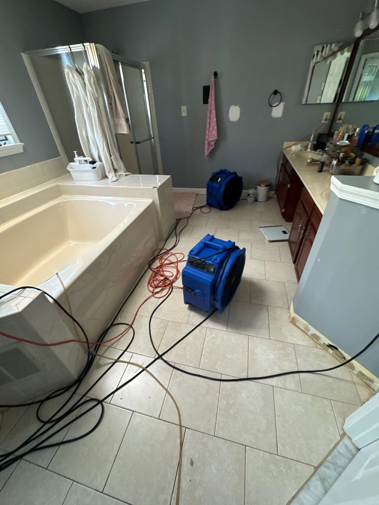 Water damage restoration in Springfield with containment barrier and dehumidifier set up around damaged ceiling area.