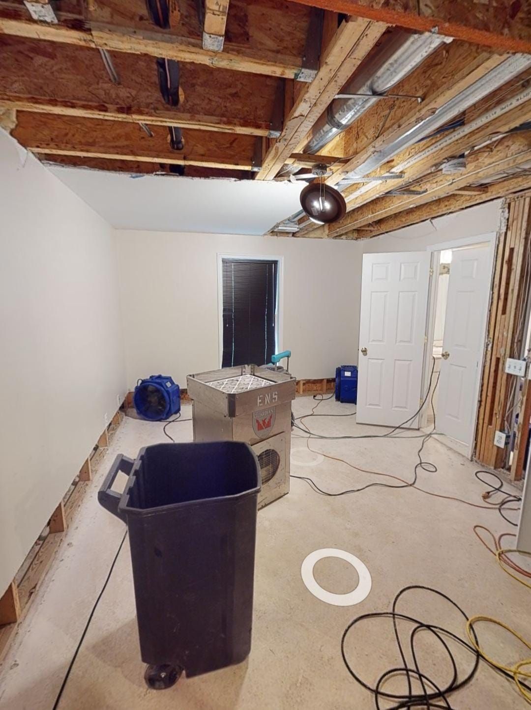 Structural drying in progress with dehumidifiers and air movers working to remove residual moisture.