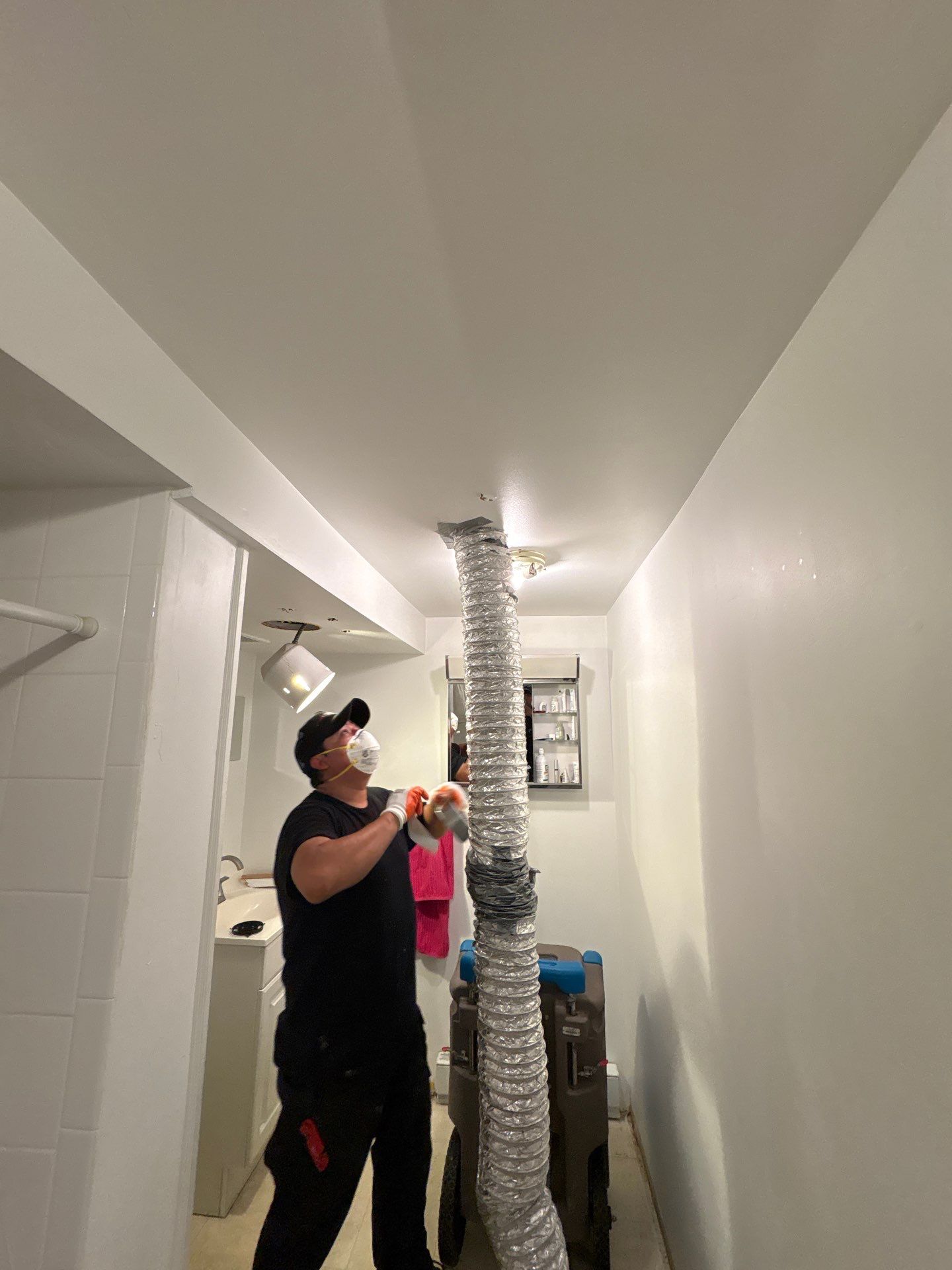 Standing water extraction underway in Vienna water damage restoration, wet flooring and structural materials visible.
