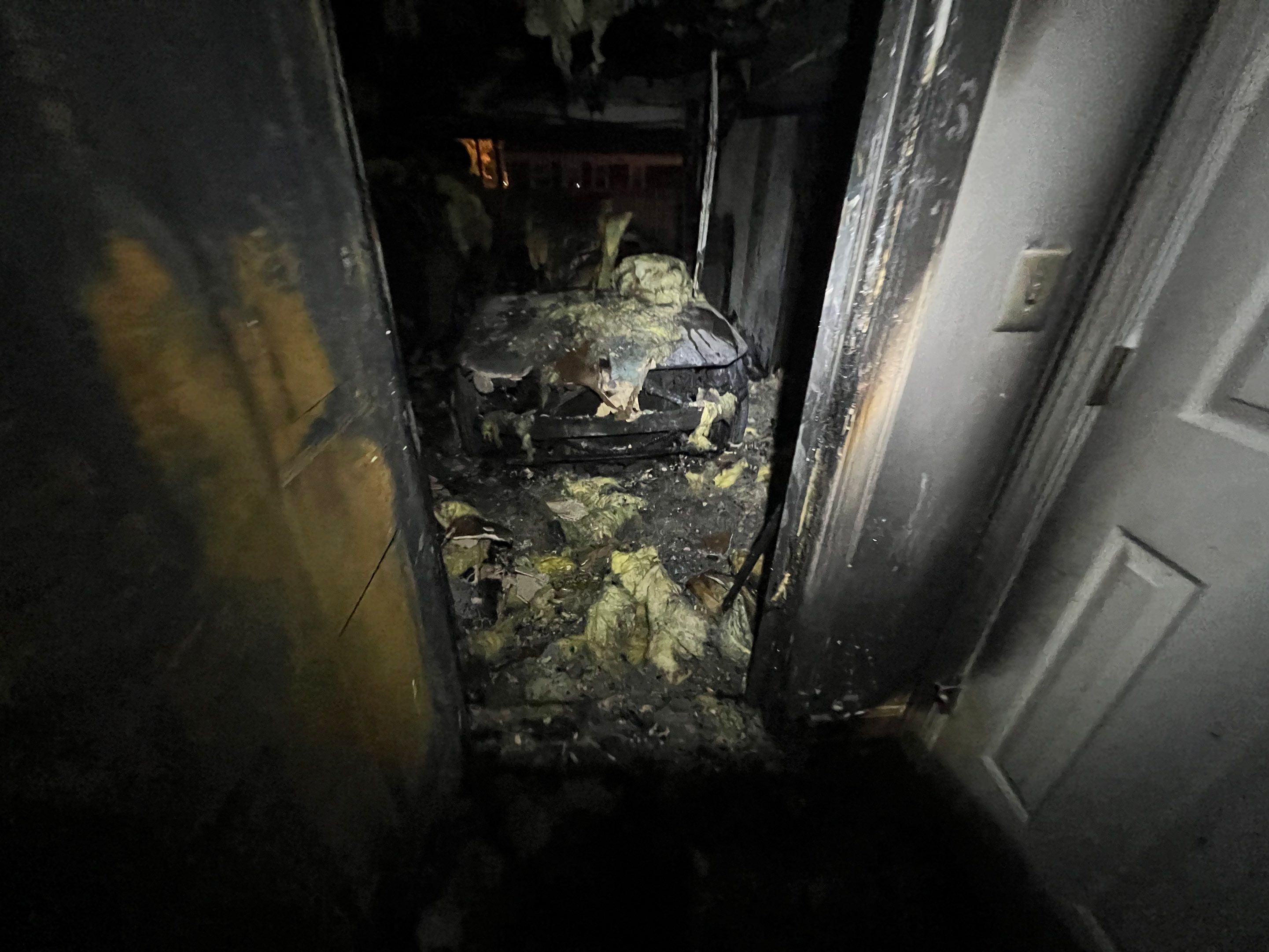 Soot removal in progress during Arlington fire restoration, technician cleaning affected wall area.