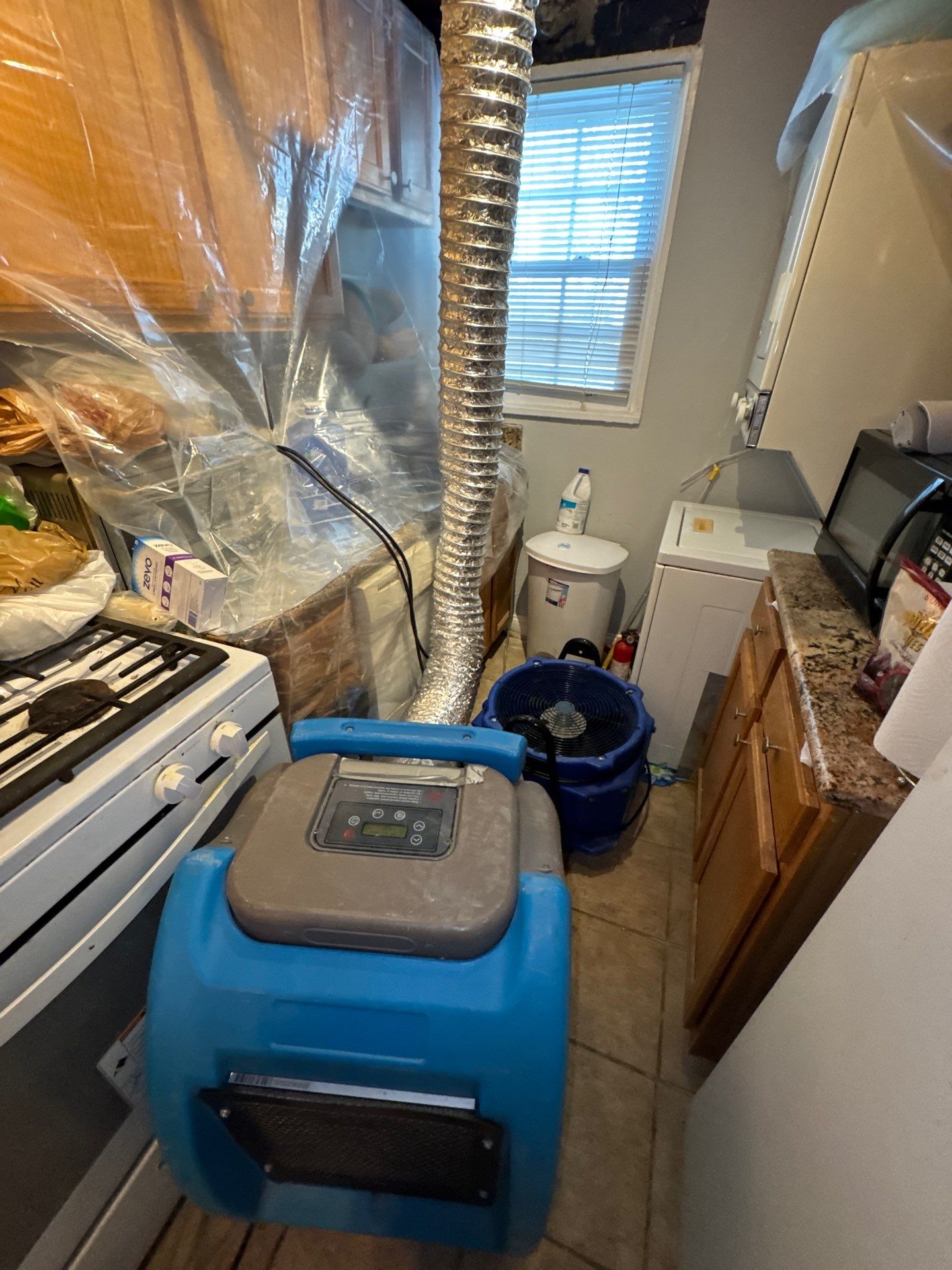 Water damage restoration in Alexandria: wet drywall and carpet after initial assessment, structural drying equipment staged.