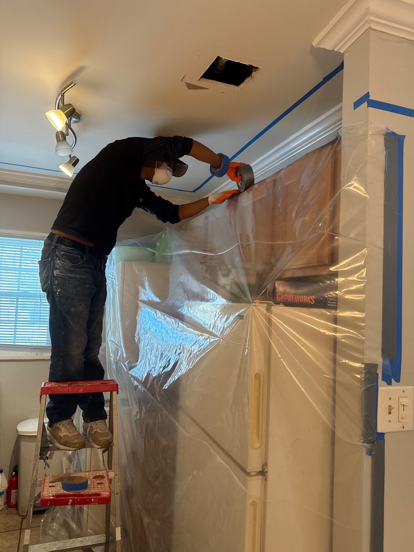 Ceiling repair underway with drywall patches installed; structural framing dried and ready for finishing work.