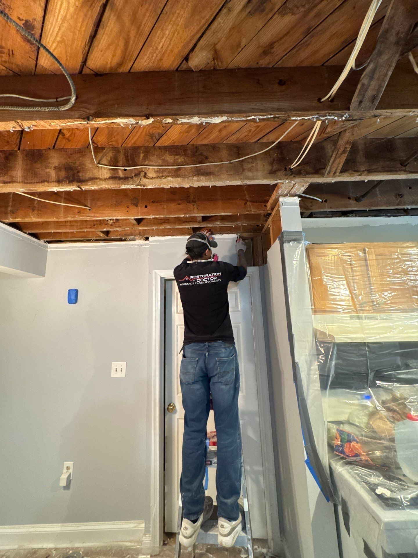 Removed carpet and padding exposing subfloor; drying continues on exposed structural elements in Alexandria home.