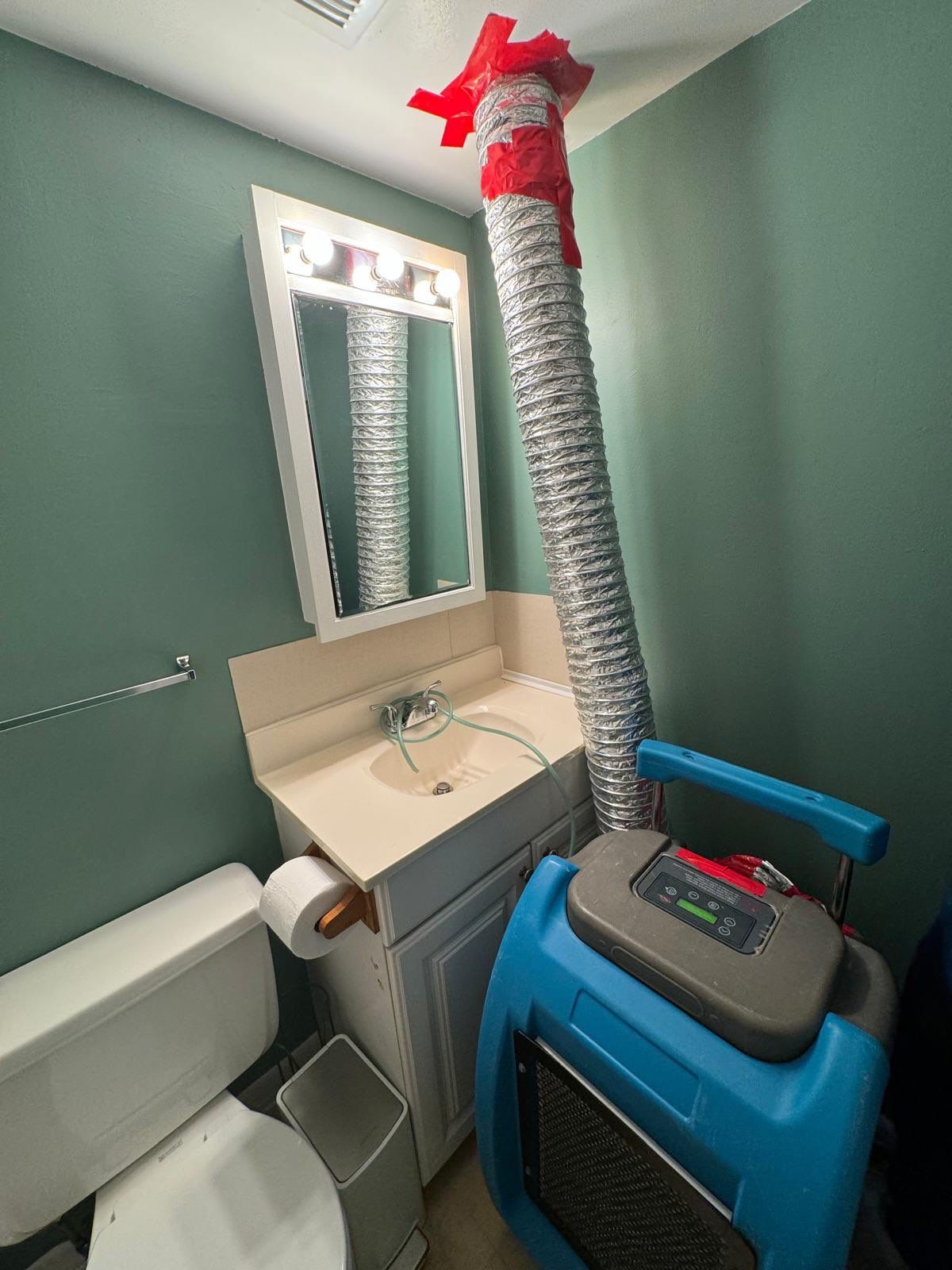 Dehumidifier and air movers positioned for structural drying after water extraction in the Annandale restoration.