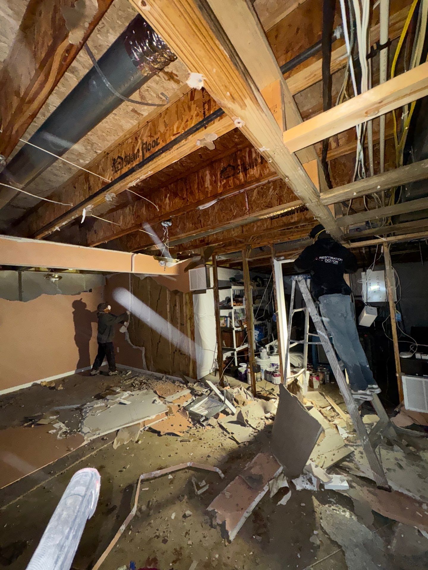 Ceiling repair underway during Manassas water damage restoration, with drying equipment continuing structural moisture removal.