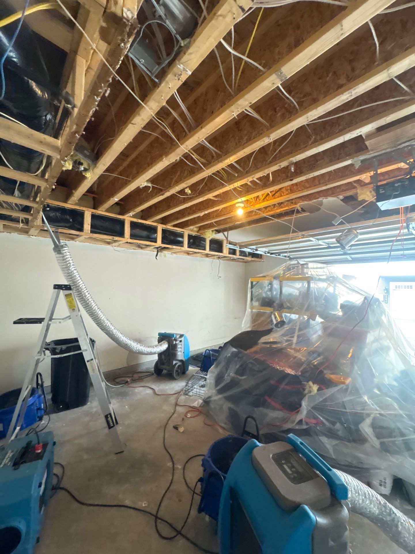 Dehumidifier and air movers positioned for structural drying during water damage restoration in Sterling.