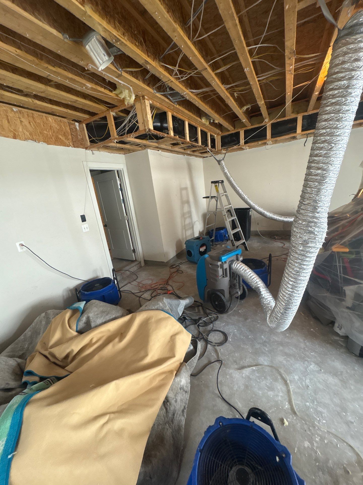 Contents staged and protected while structural drying equipment operates in damaged area.
