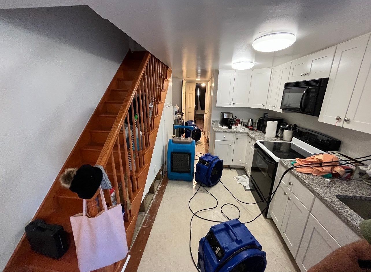 Dehumidifiers and air movers operating to dry structural materials following water extraction phase.