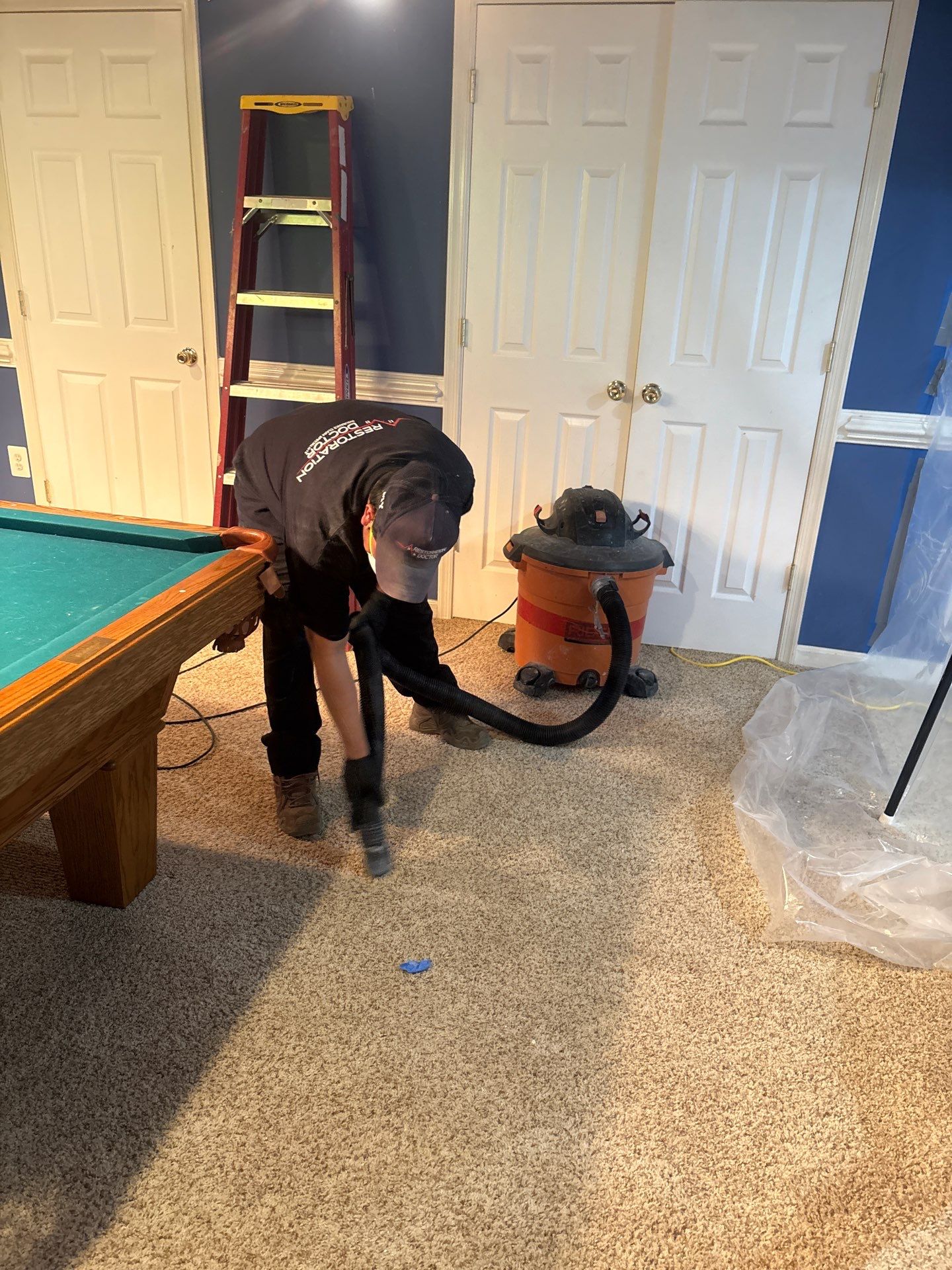 Mid-stage drying setup showing dehumidifiers and air movers working to extract moisture from affected flooring and framing.