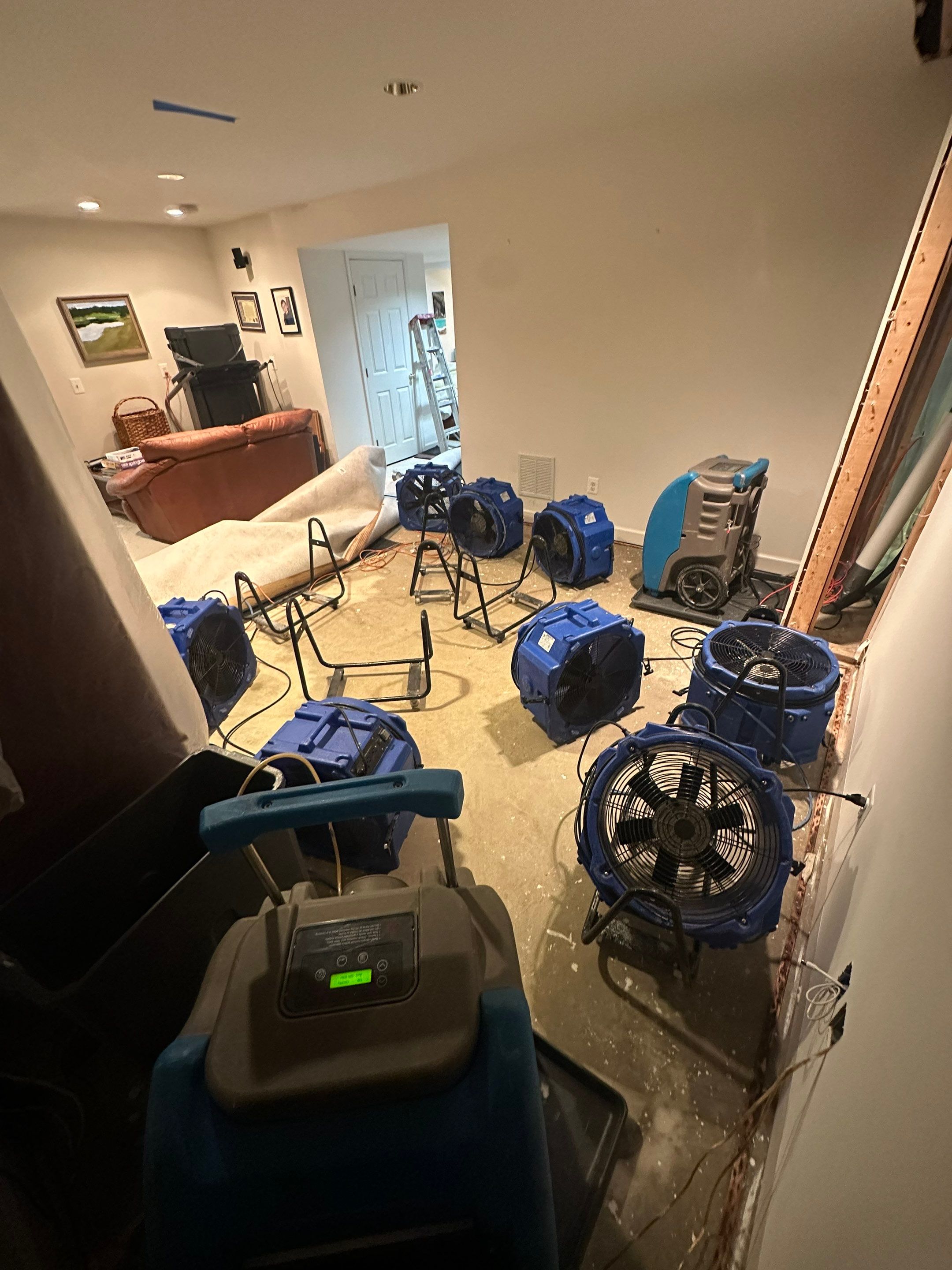 Standing water extraction underway in Ashburn water damage restoration, wet flooring visible.