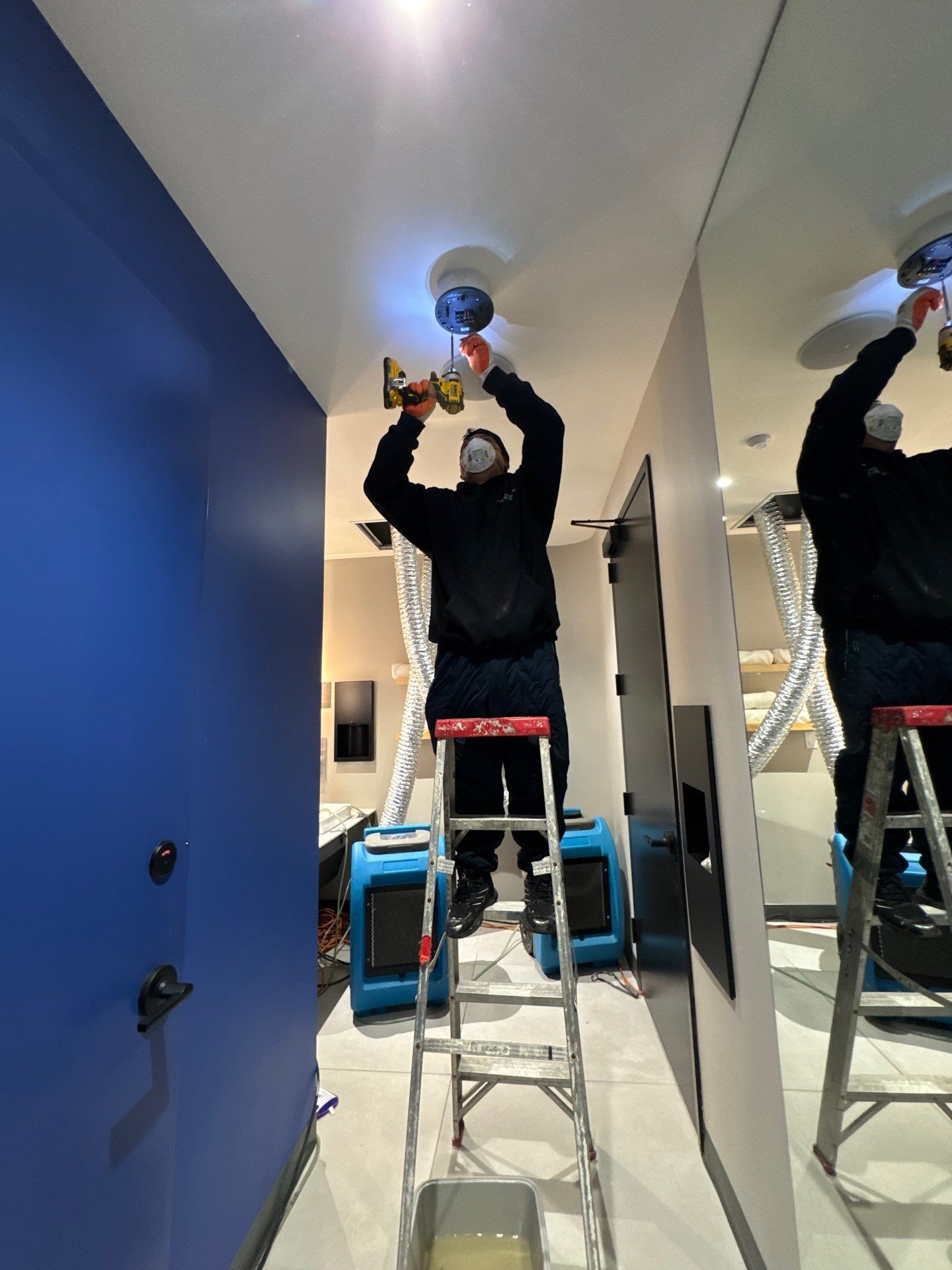 Standing water extraction underway in Tysons water damage restoration, wet flooring visible.