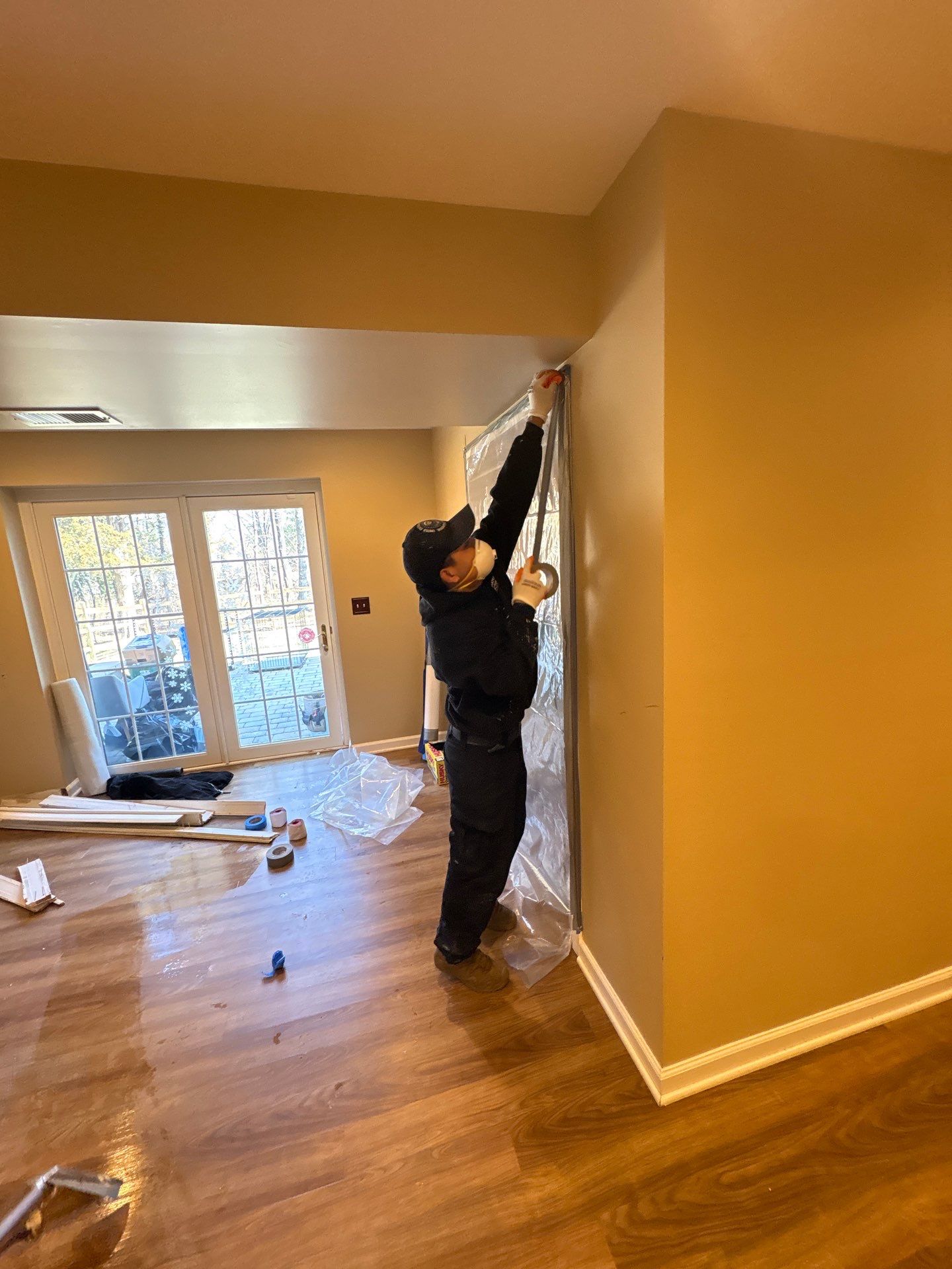 Baseboard removal and preparation for replacement as part of mold remediation containment protocol.