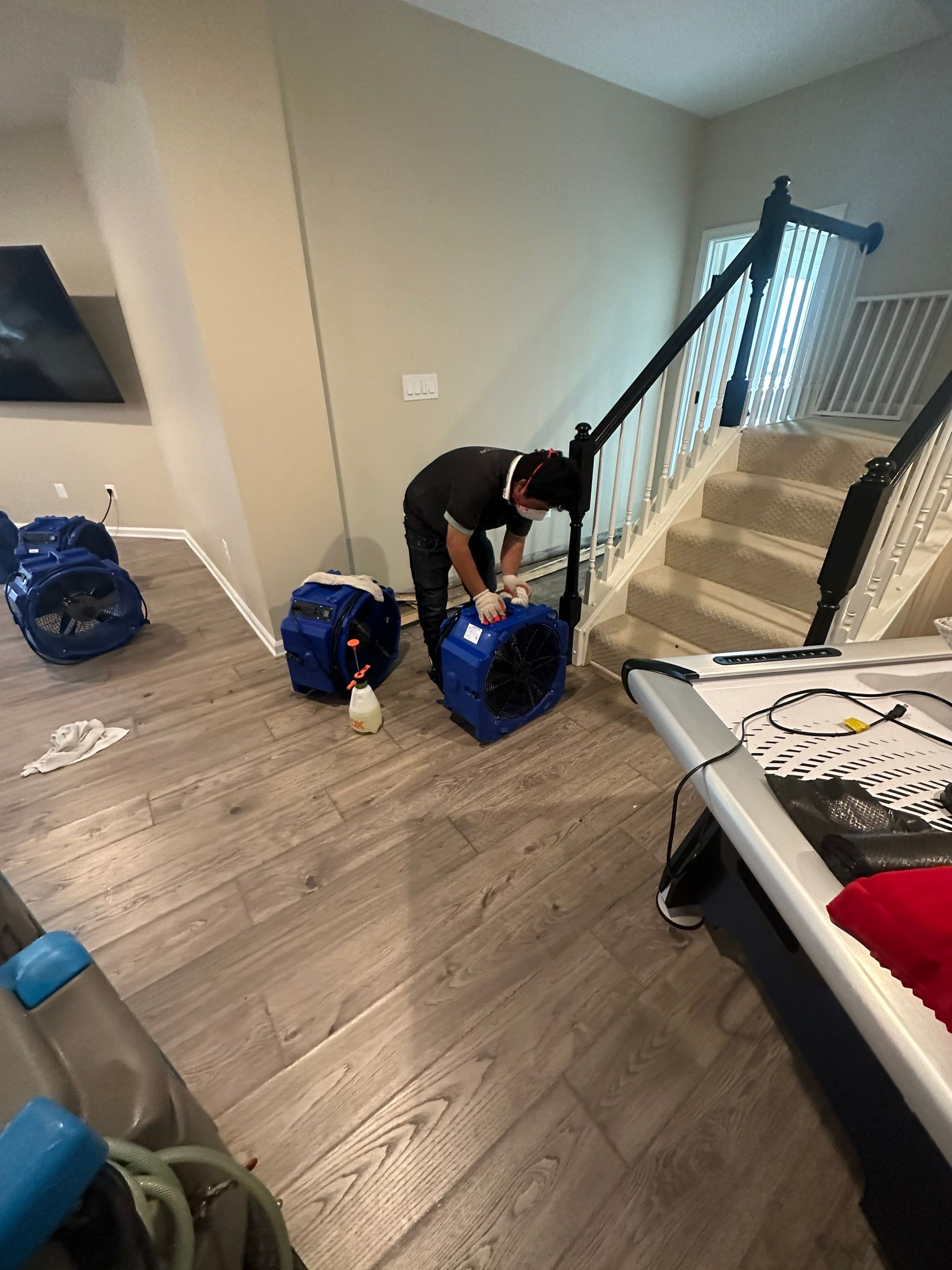 Standing water extraction underway in Aldie water damage restoration, removing pooled water from affected interior space.
