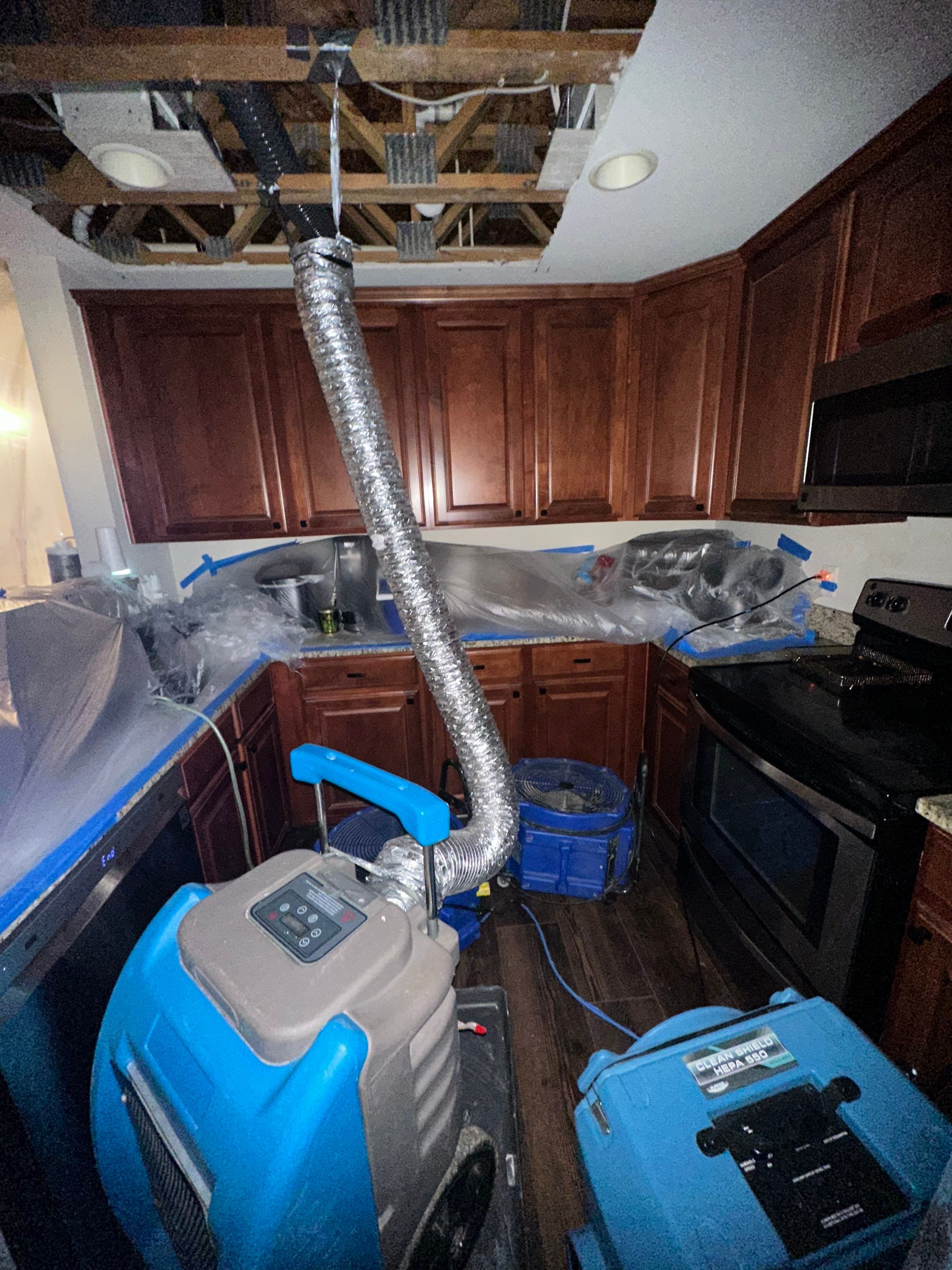 Negative air unit and dehumidifier running to control moisture during mold remediation containment.