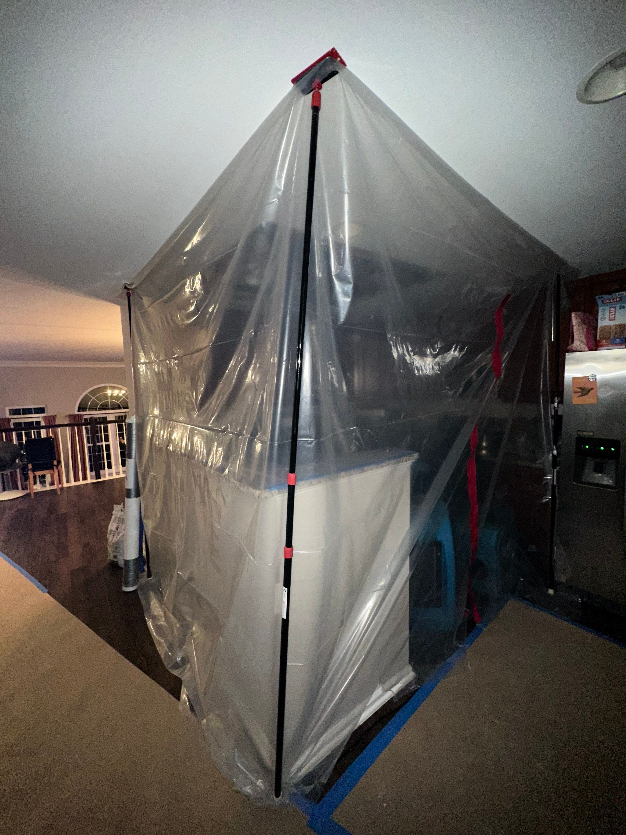 Antimicrobial application in progress within sealed containment barrier during Aldie remediation.