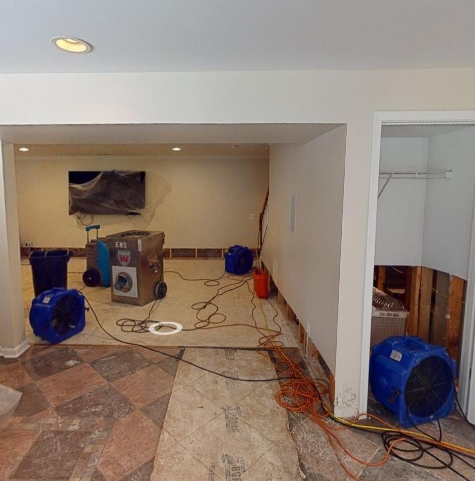 Mid-stage drying process showing dehumidifiers and air movers working to extract moisture from affected areas.