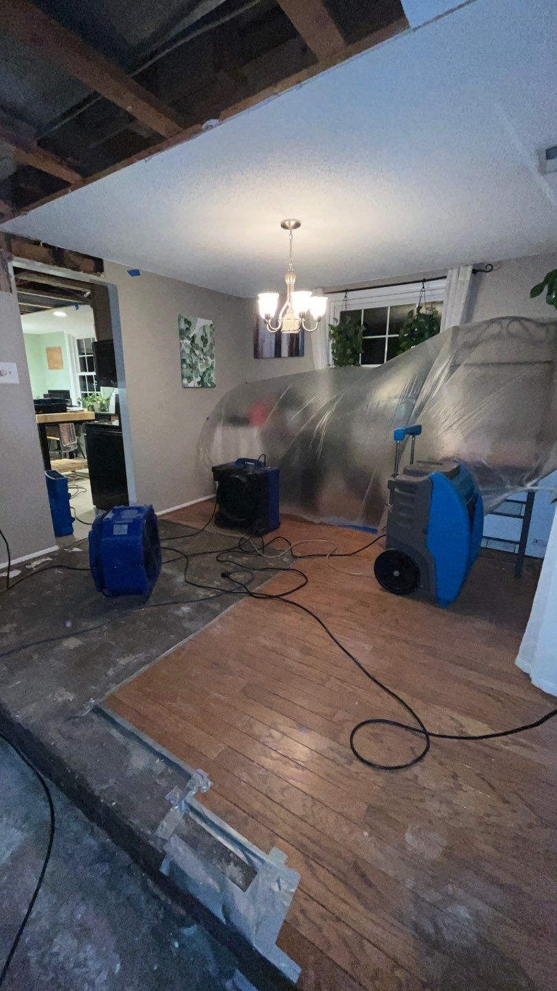 Standing water extraction underway in Sterling water damage restoration, removal equipment deployed indoors.