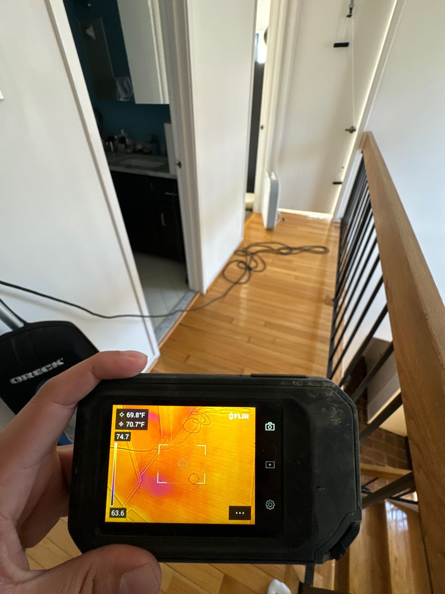 Thermal imaging camera documenting moisture patterns during Fairfax water restoration process.