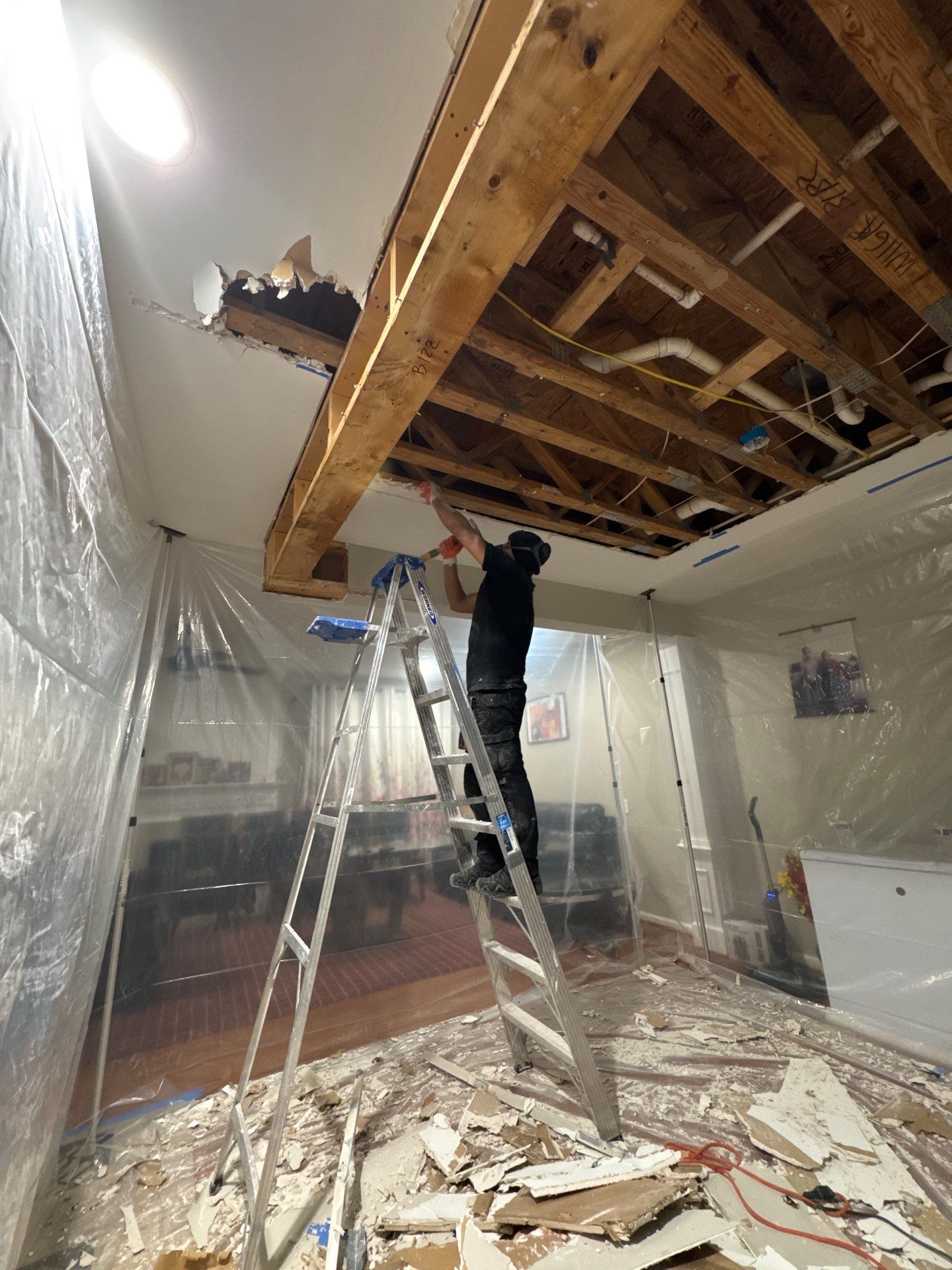 Moisture inspection equipment positioned to map affected drywall and framing above damaged ceiling area.