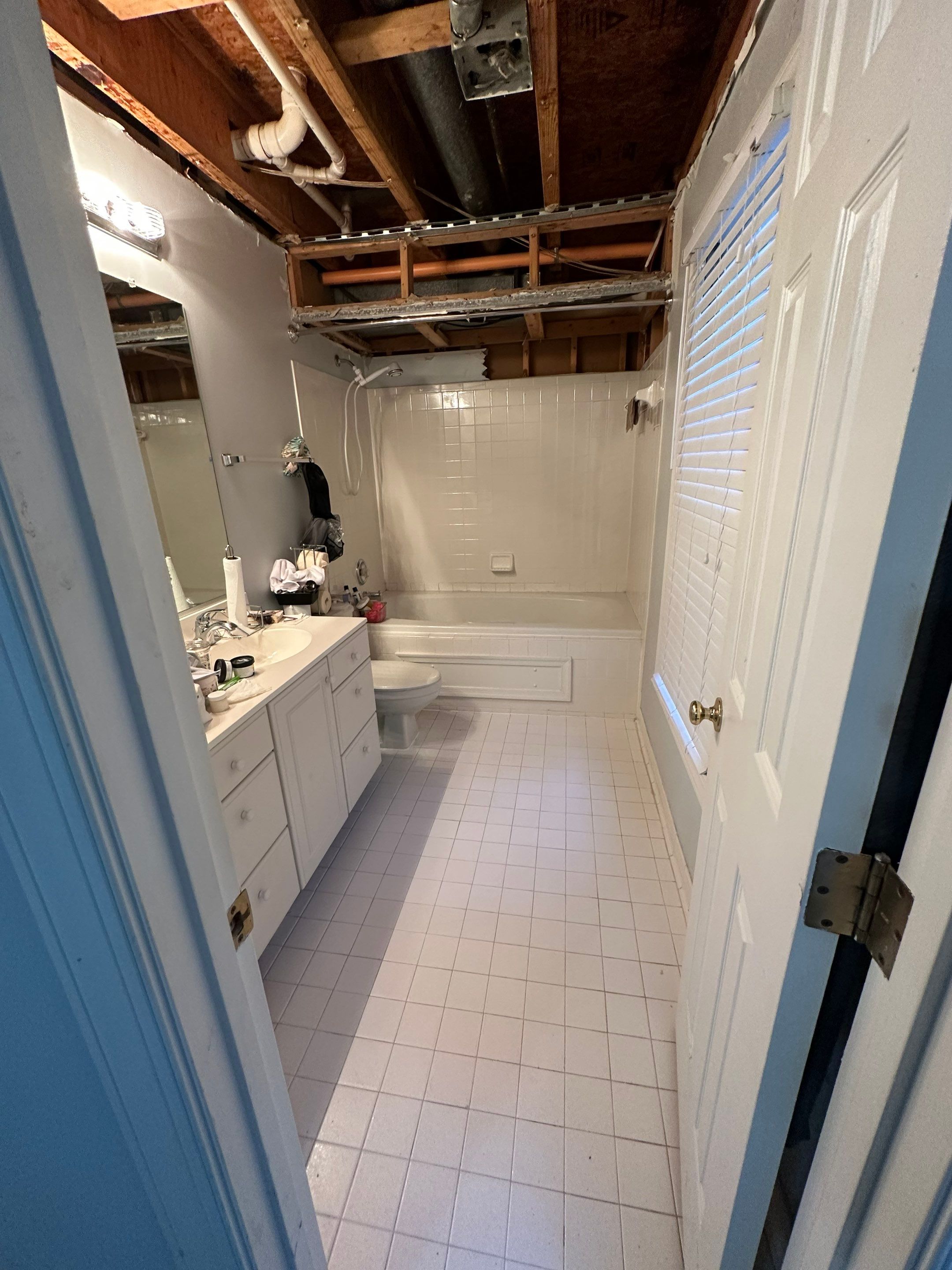 Water damage restoration in Fairfax: dehumidifier and drying equipment positioned in affected room during initial assessment phase.