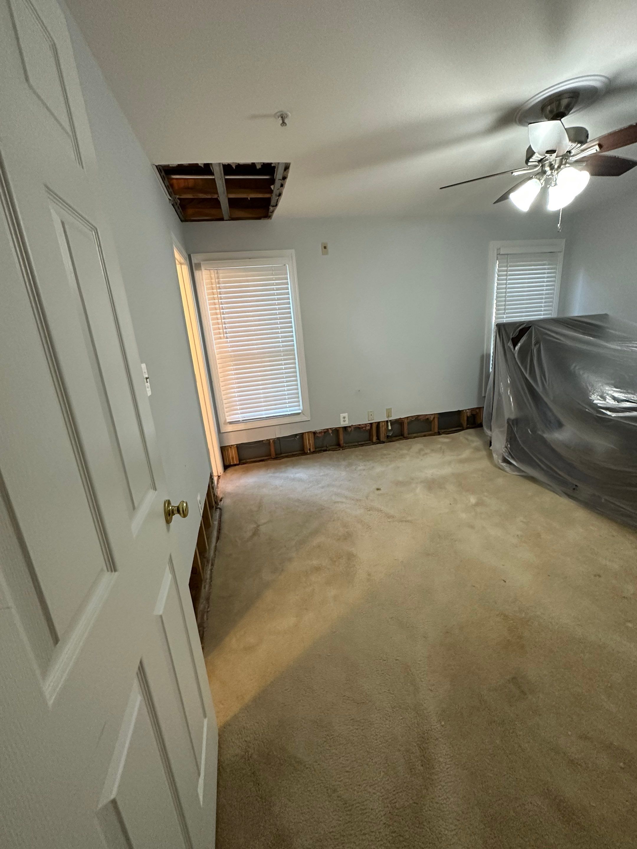 Structural drying in progress with dehumidification equipment operating to extract moisture from walls and framing.