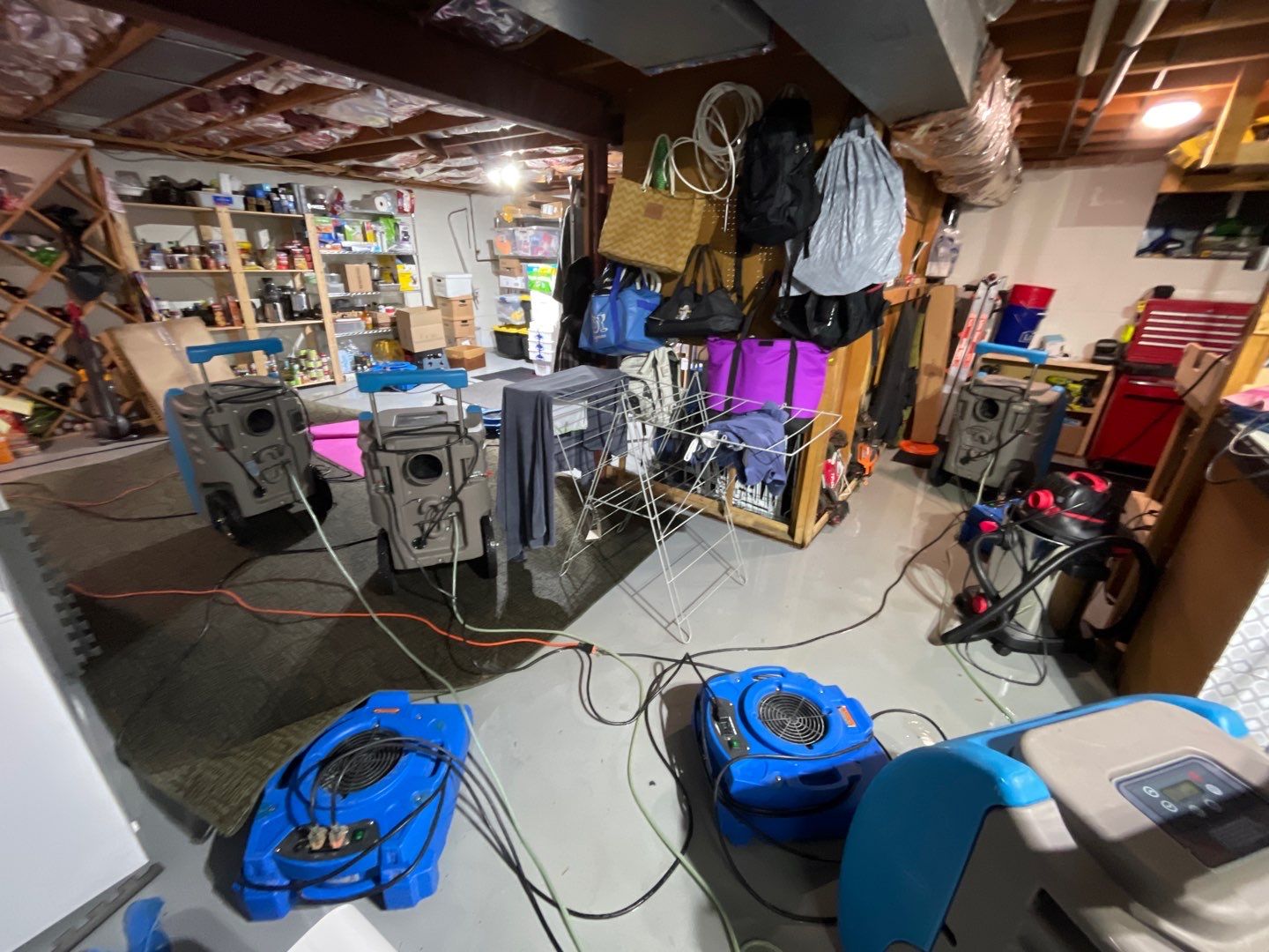 Dehumidifiers and air movers positioned for structural drying after water extraction in Herndon.