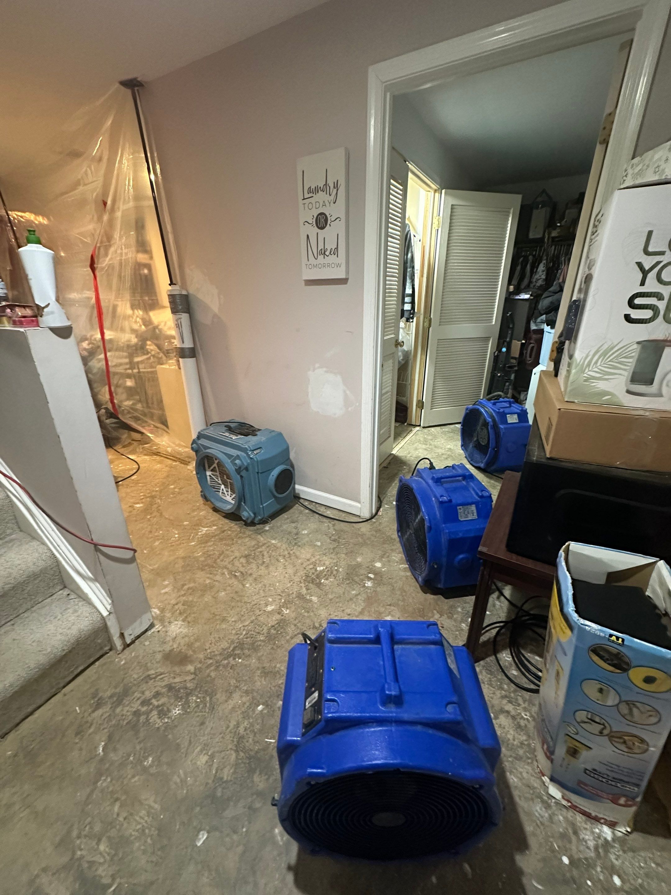 Standing water extraction underway in Dumfries water damage restoration, wet carpet and flooring visible.