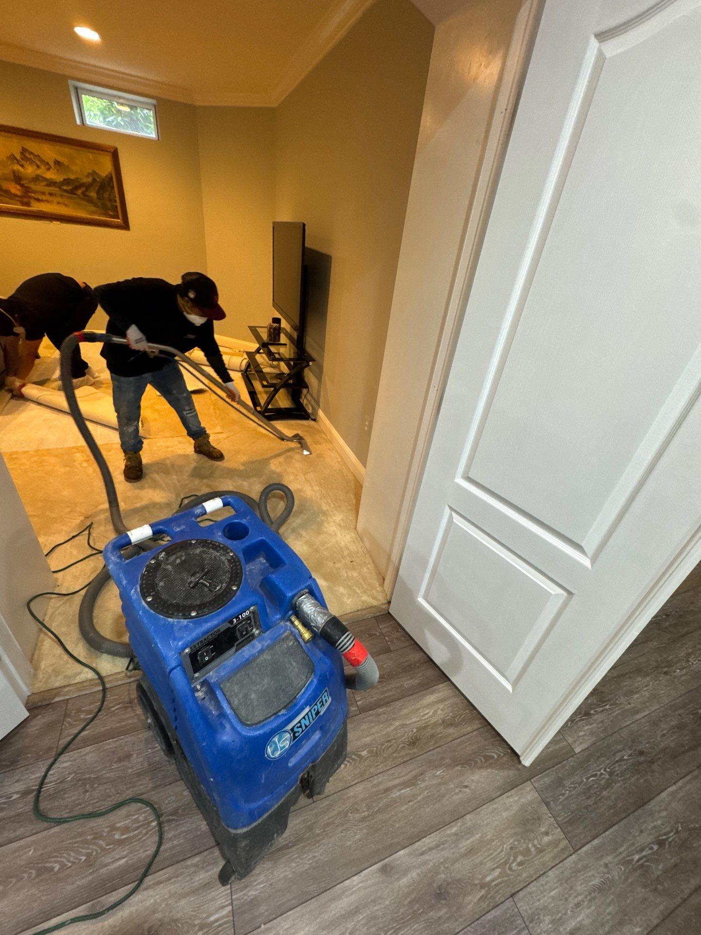 Dehumidifiers and air movers operating to dry structural materials after water extraction.