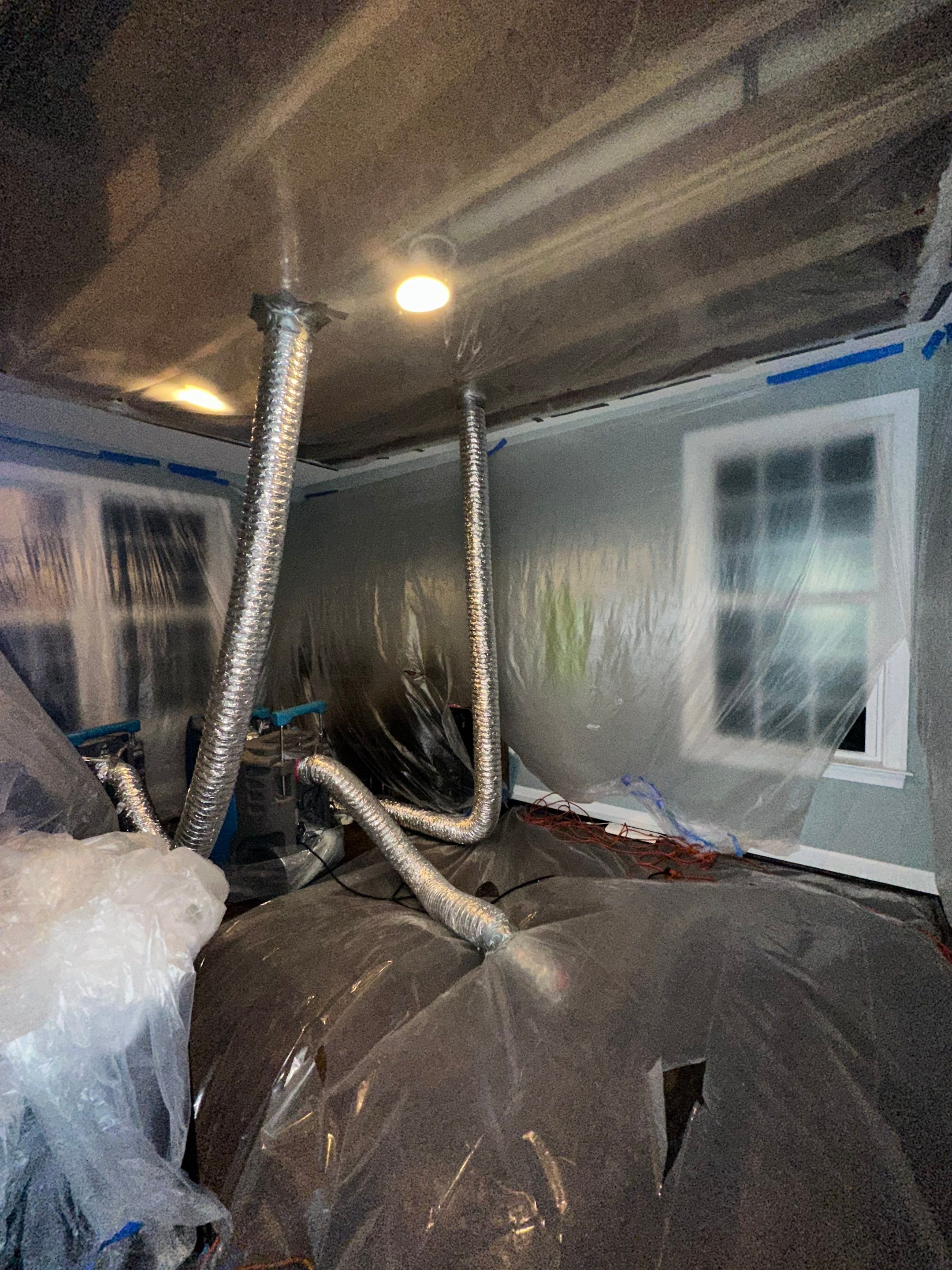Water damage restoration in Leesburg: wet structural materials and drying equipment positioned for moisture extraction.