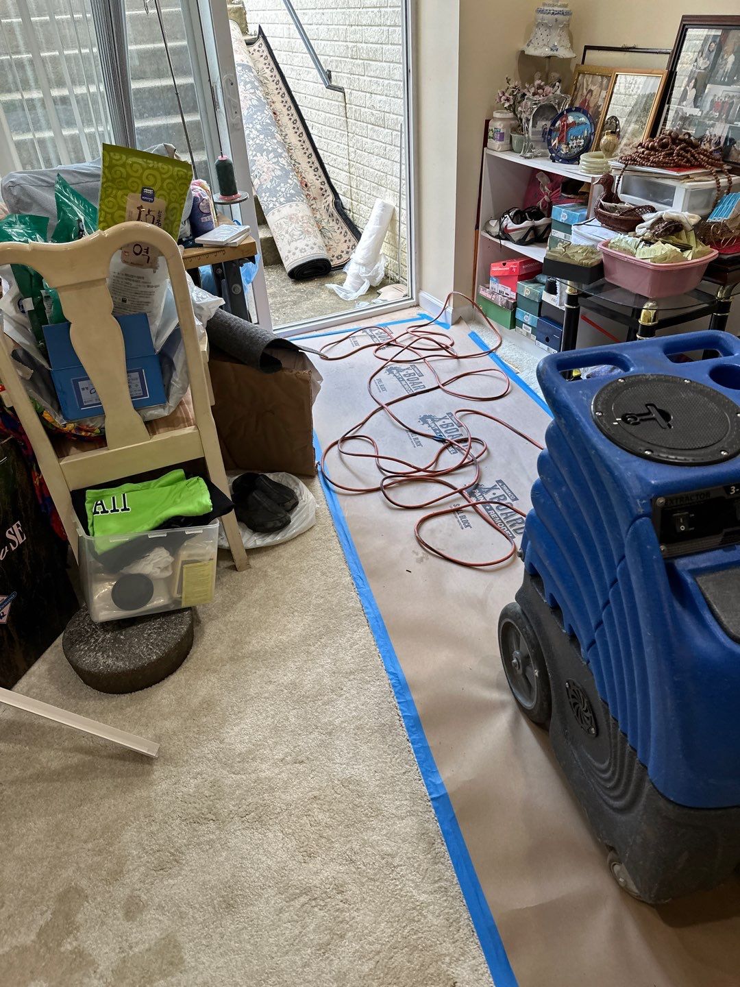 Dehumidifiers and air movers operating to dry structural materials after water extraction.