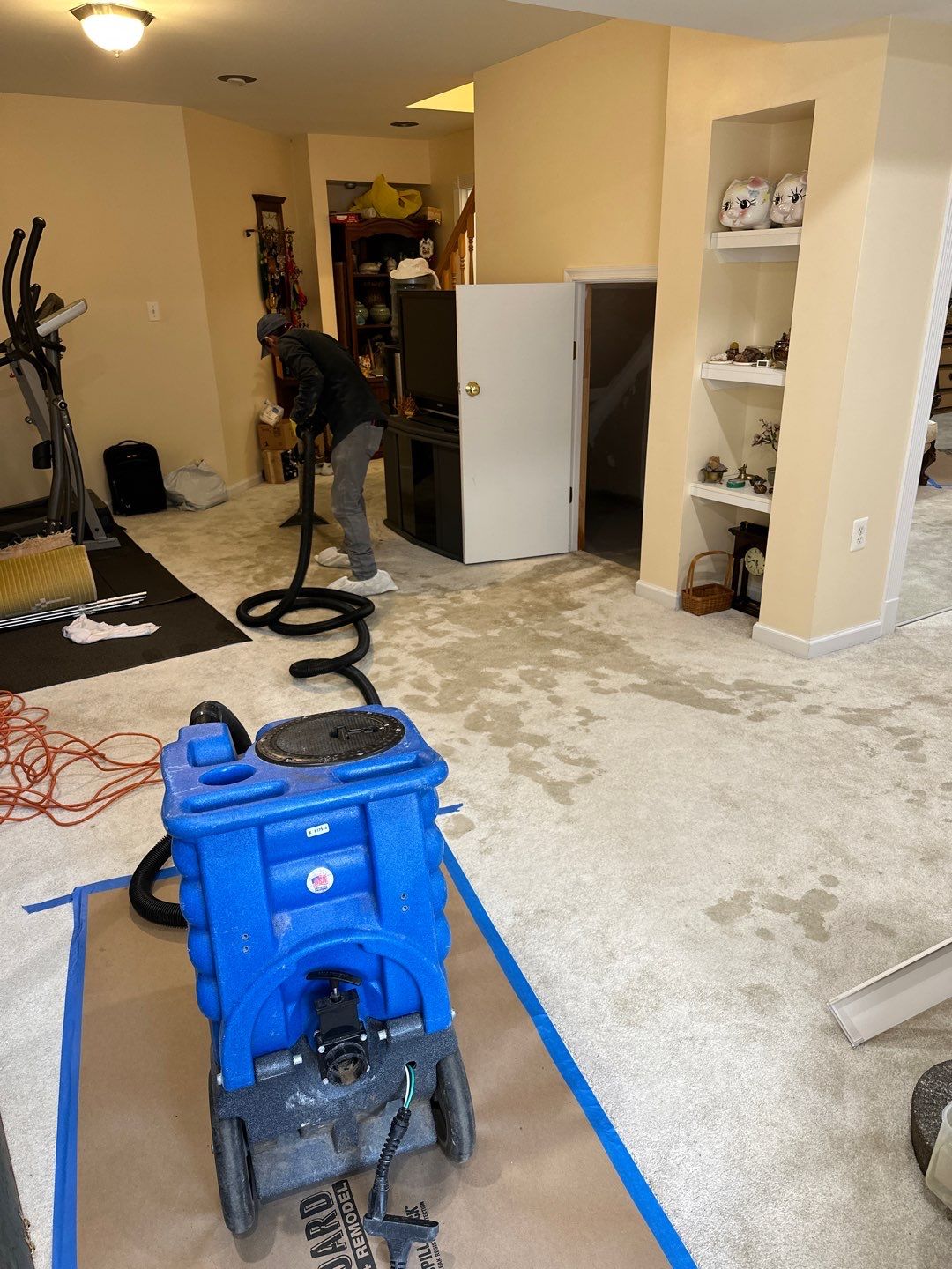 Structural drying equipment positioned throughout affected room during water damage mitigation.