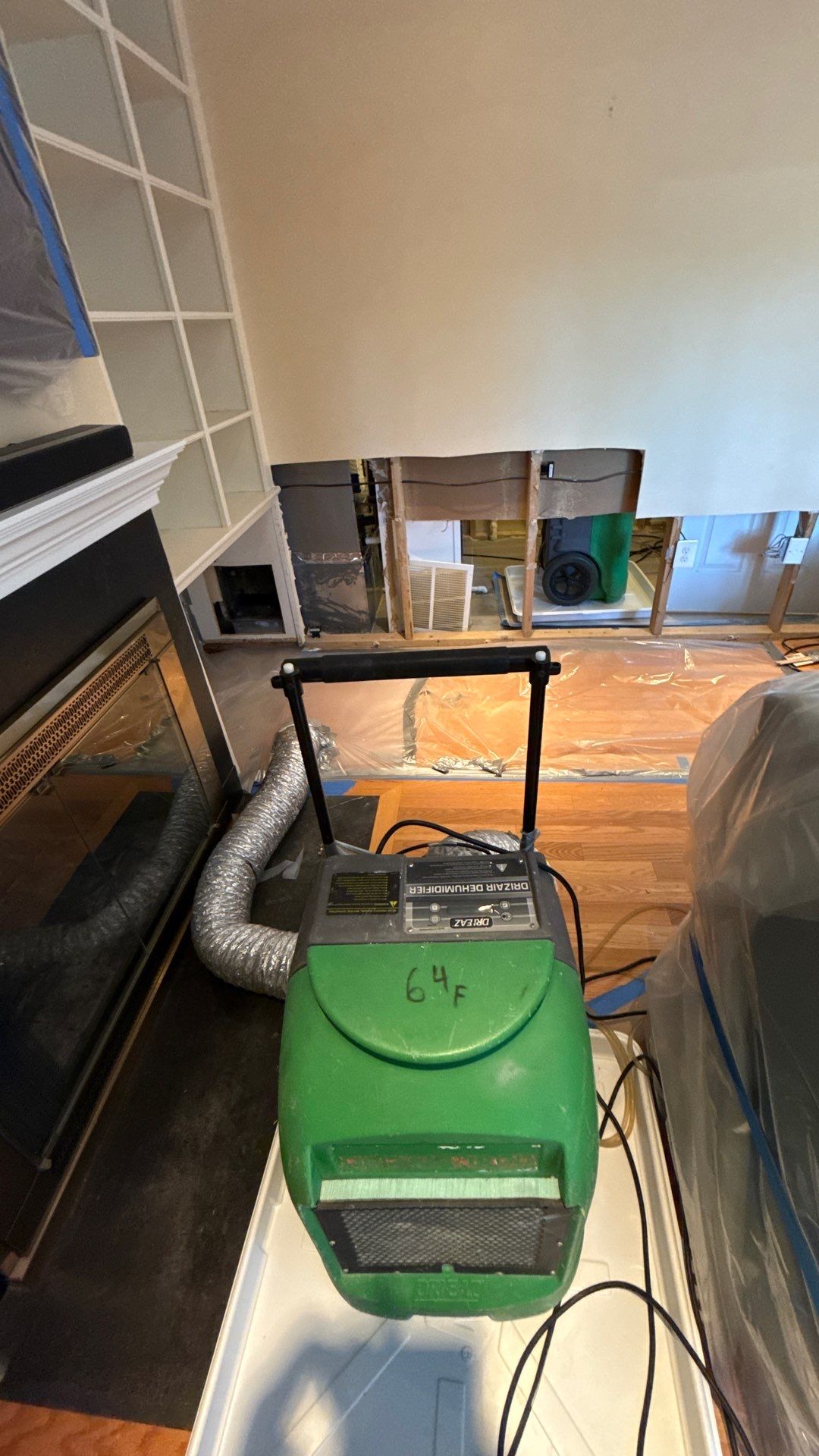 Structural drying equipment positioned to remove moisture from walls and subfloor after water extraction.