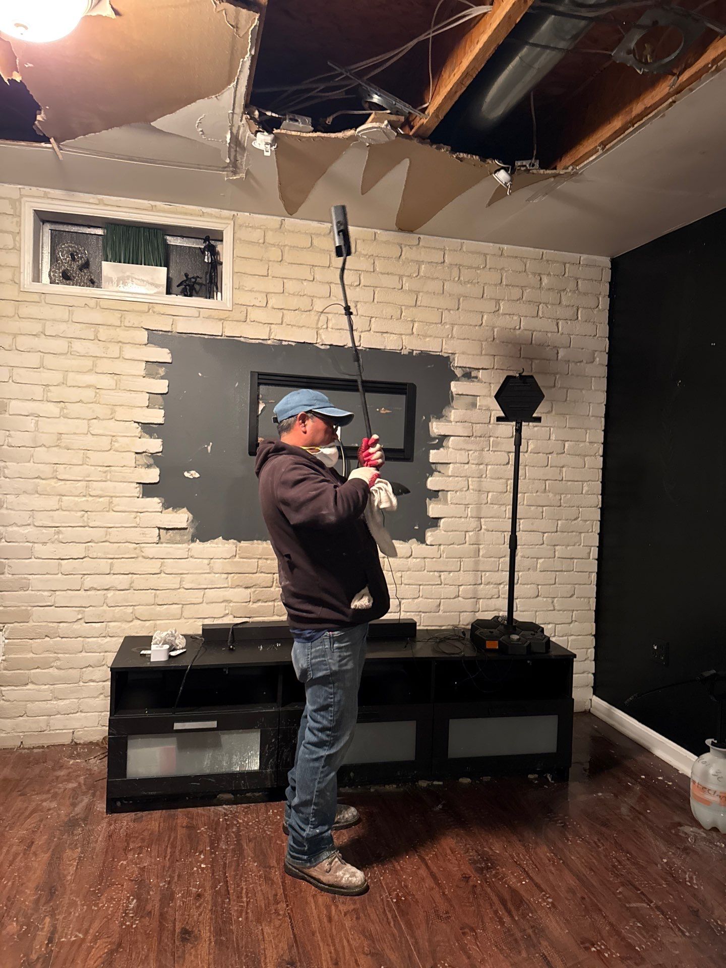Damaged ceiling section removed to assess extent of water intrusion and structural impact.