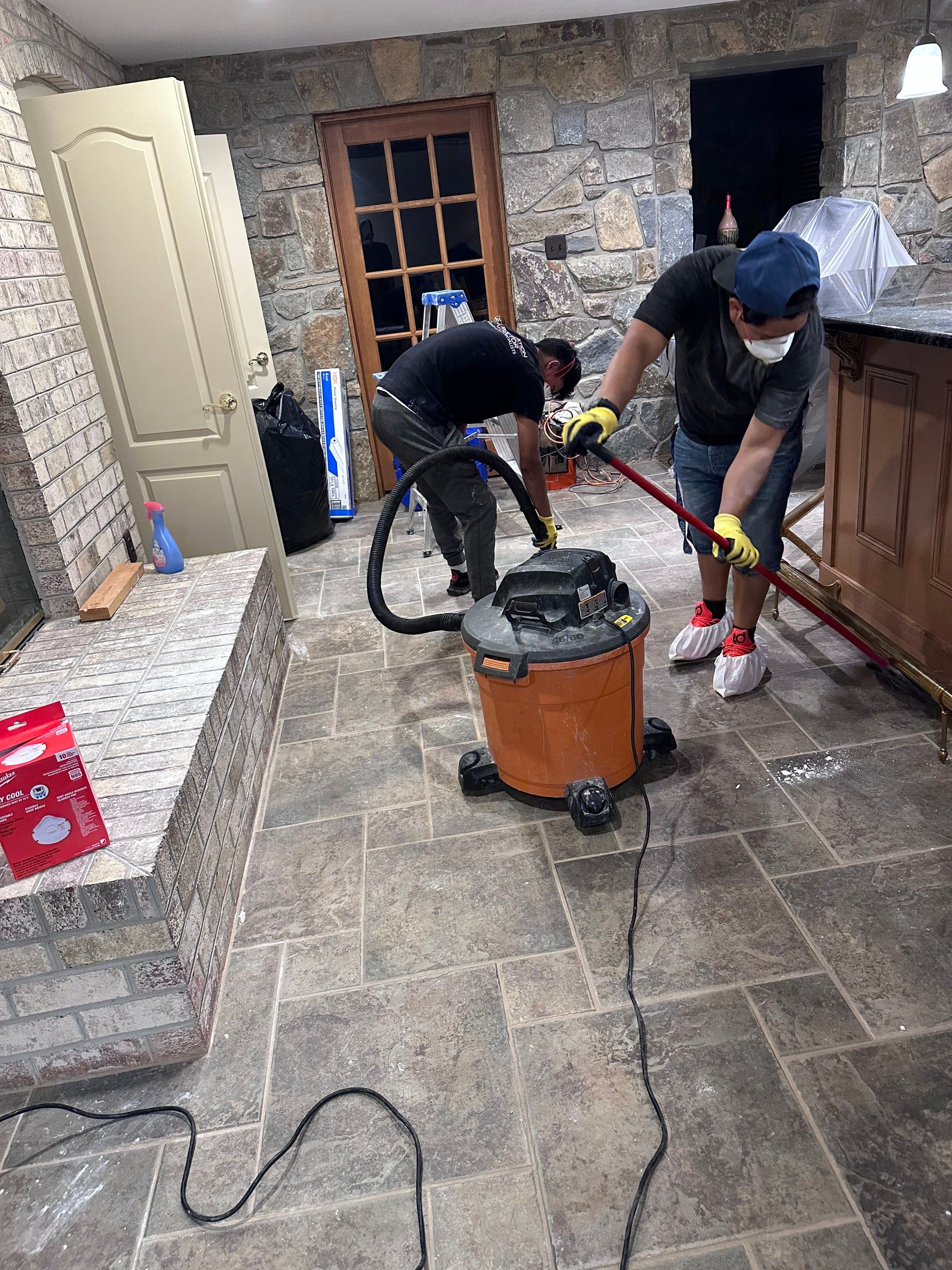 Standing water extraction in progress using commercial equipment within containment zone.