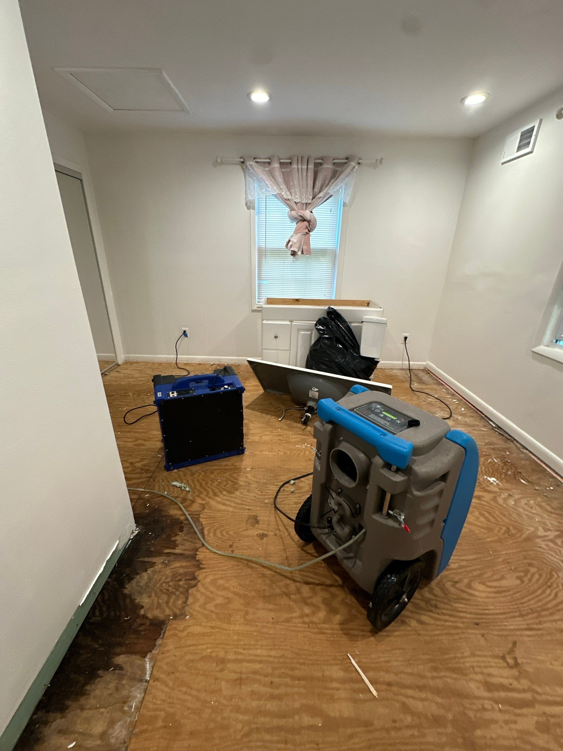Mid-stage drying with dehumidifiers and air movers positioned for structural moisture extraction.