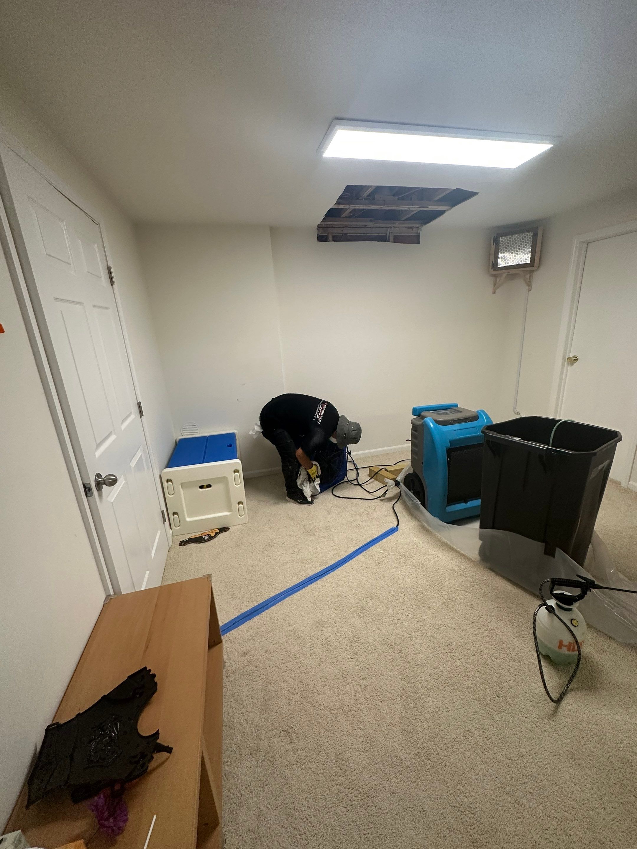 Dehumidifier and air movers positioned for structural drying during moisture remediation.