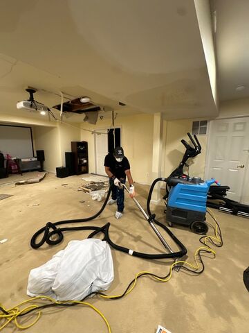 Technician conducting thermal-imaging inspection to identify residual moisture behind walls and flooring.