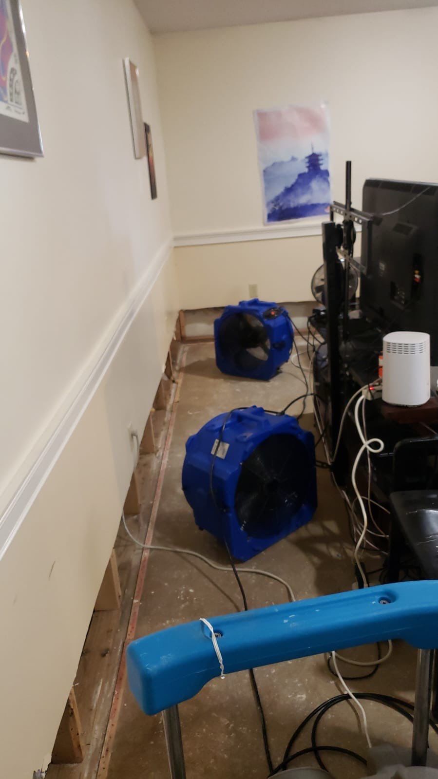 Mid-stage drying setup showing dehumidifiers and air movers managing moisture extraction from affected flooring areas.