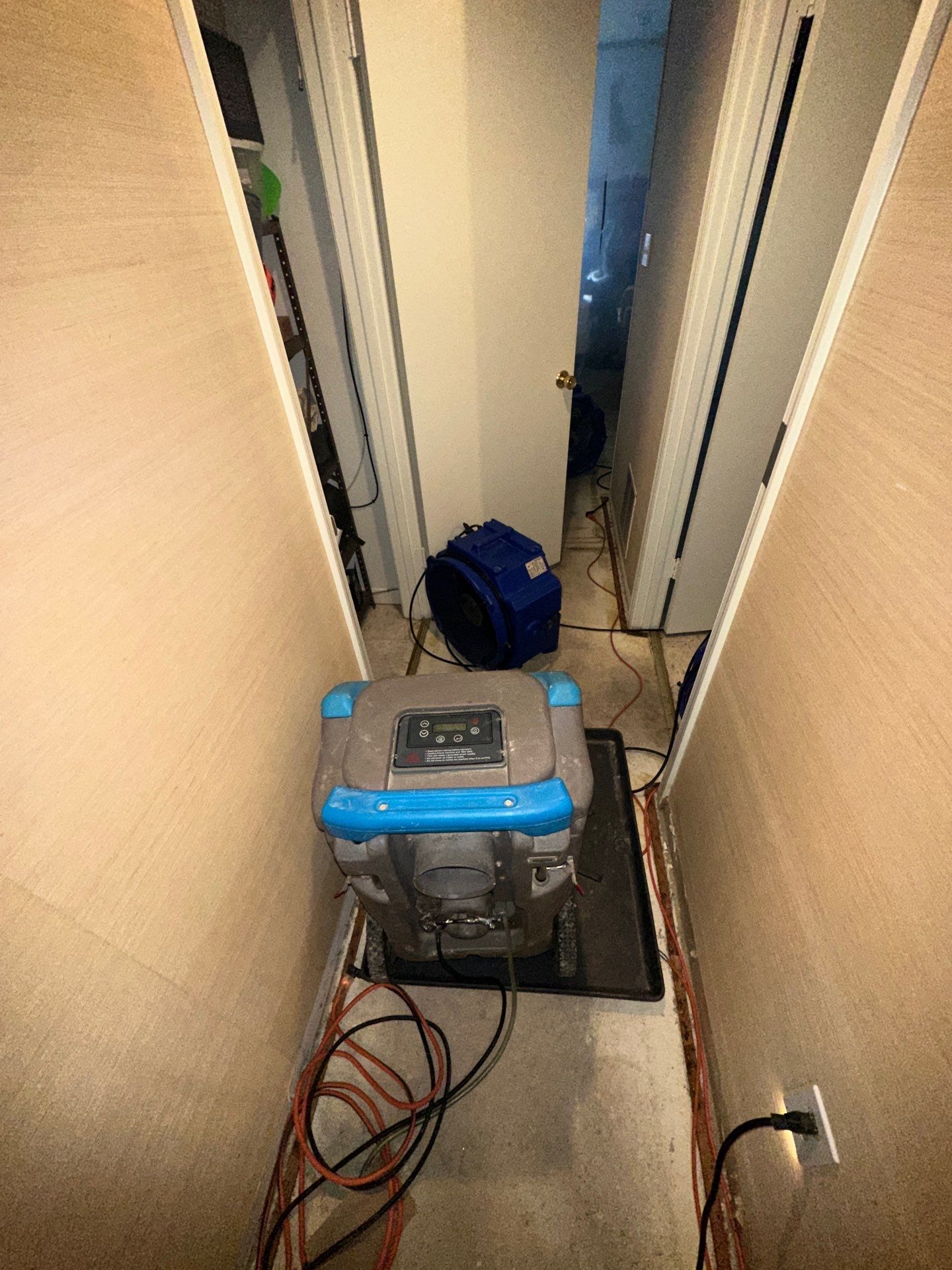 Standing water extraction underway in Ashburn water damage restoration, wet flooring and structural materials visible.