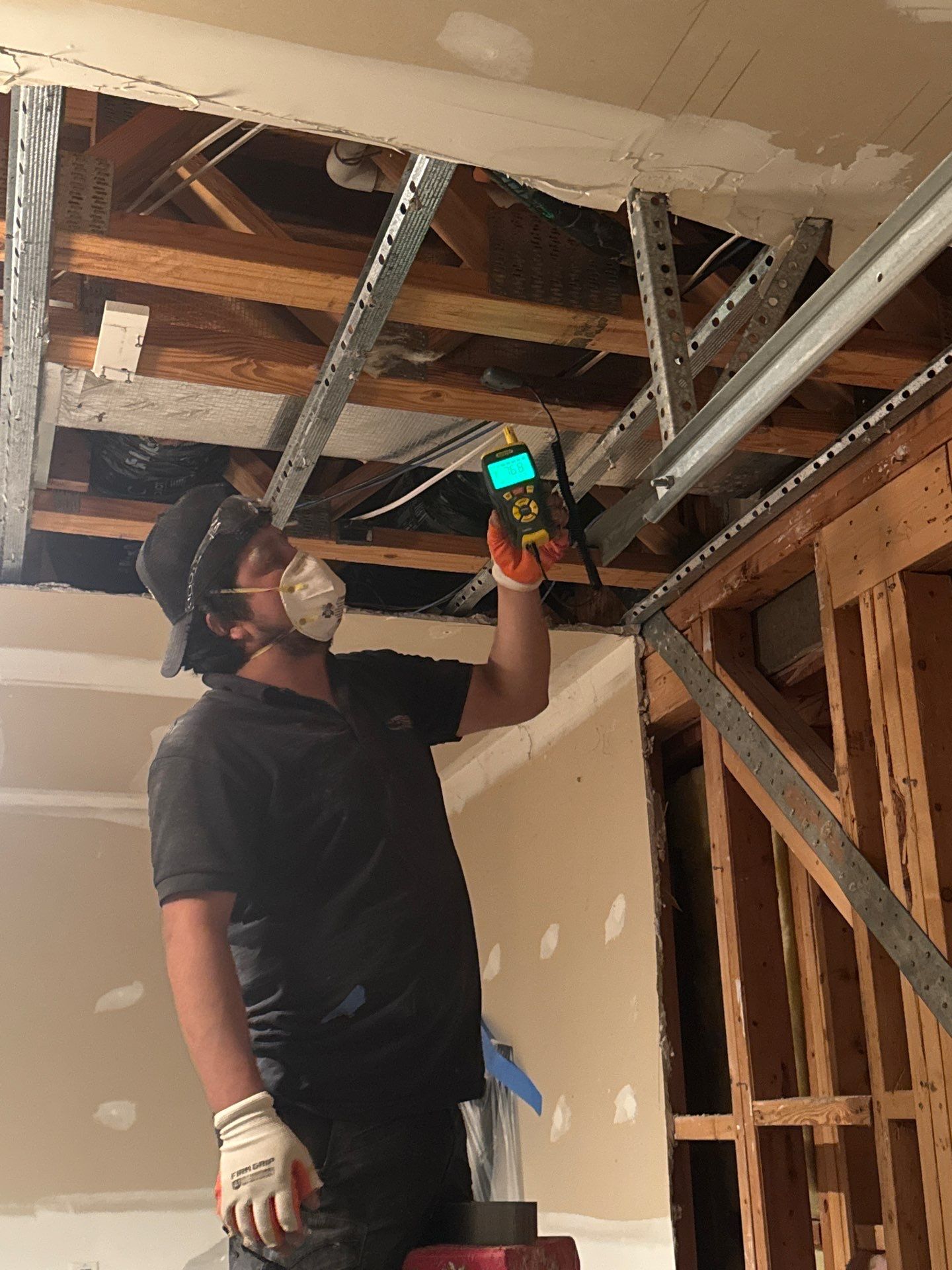 Wall cavity inspection during Ashburn water restoration, assessing framing and substrate saturation levels.