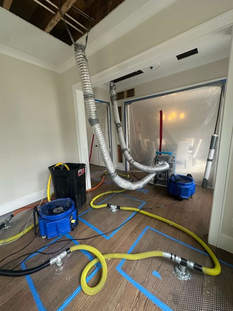 Thermal imaging camera documenting moisture distribution across affected surfaces during drying phase.