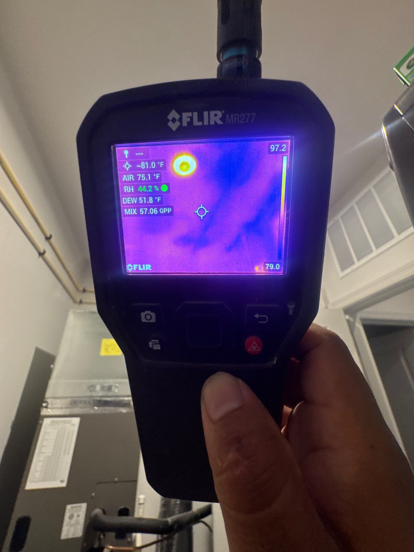 Structural drying equipment positioned to remove moisture from affected ceiling cavity and framing.