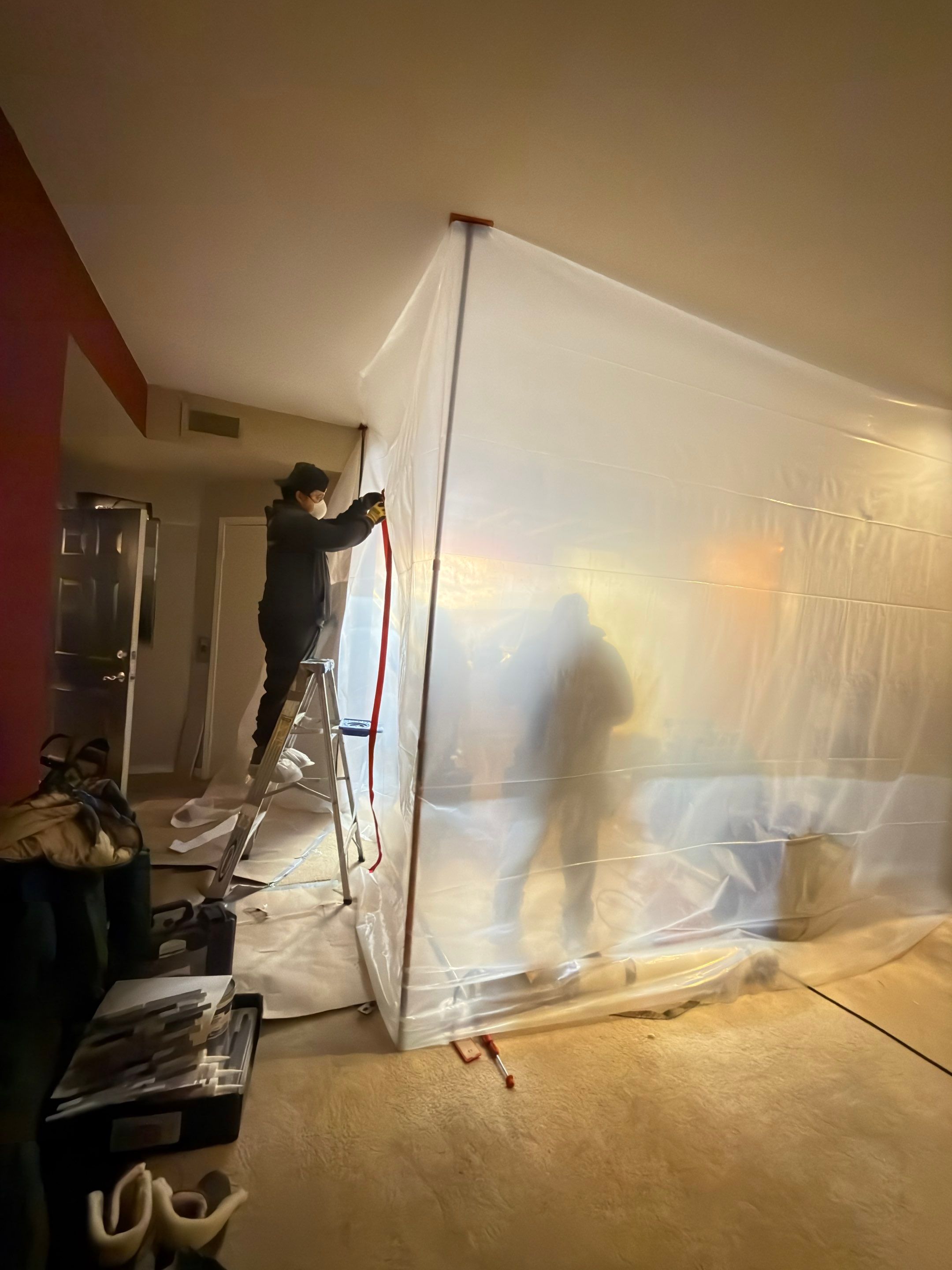 Containment barrier isolates remediation work from occupied spaces.