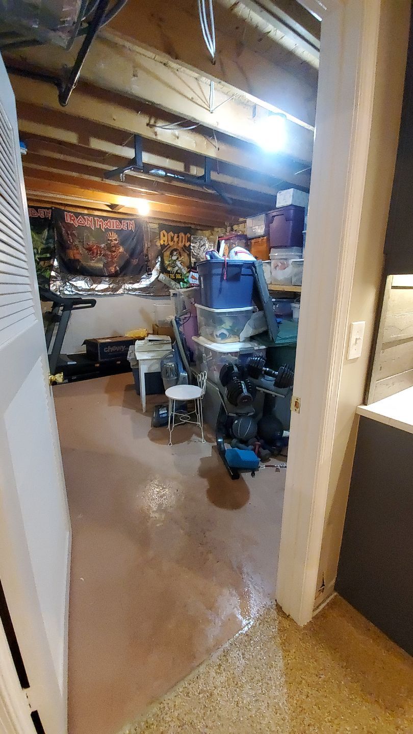 Water-damaged carpet and flooring in Ashburn home with dehumidification equipment positioned for structural drying.