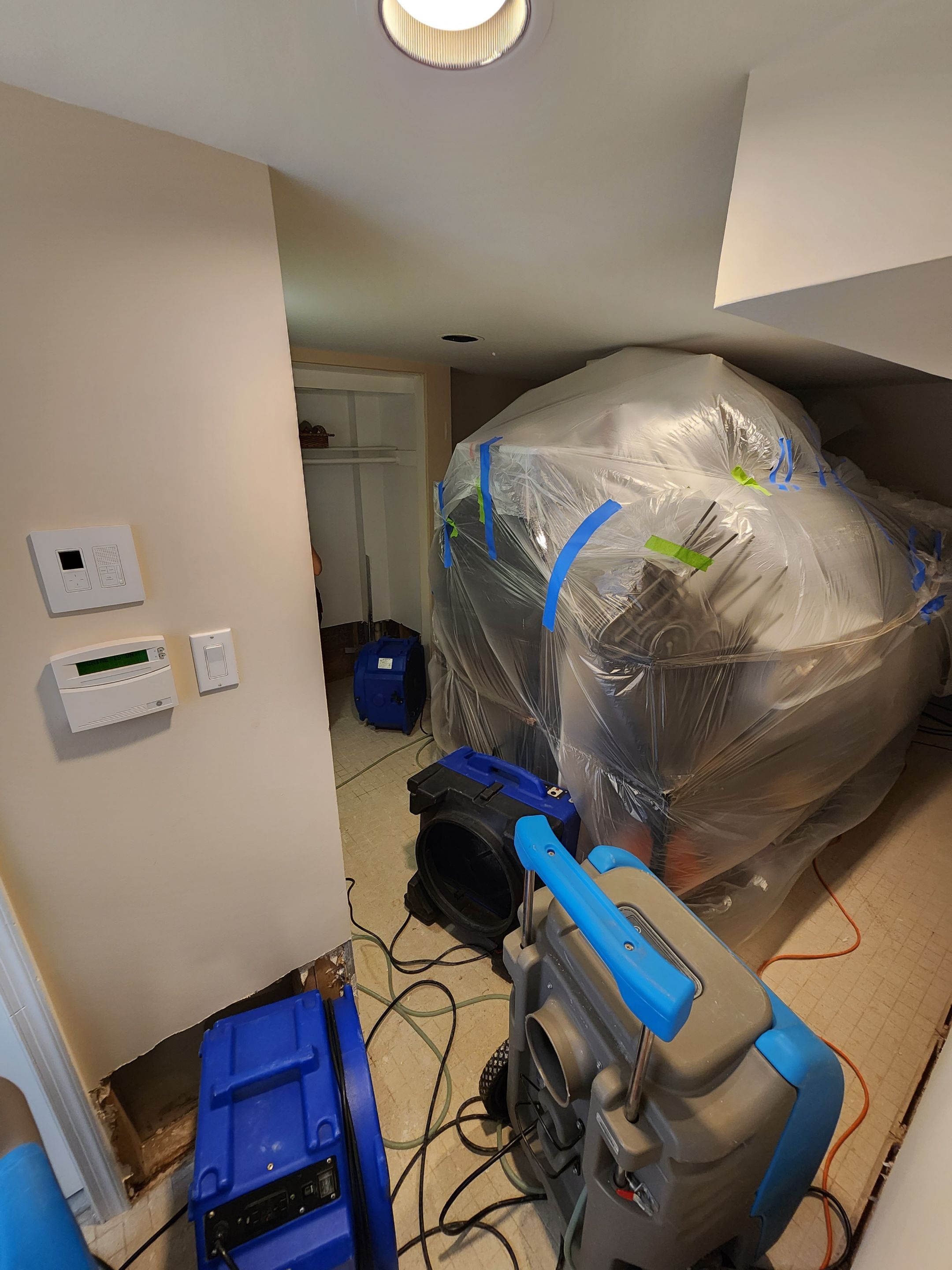 Standing water extraction underway in Washington water damage restoration, wet flooring visible.